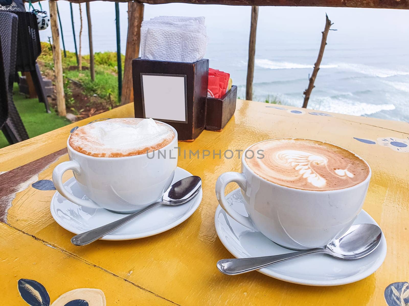 Breakfast facing the sea, two cups of cappuccino. by Peruphotoart