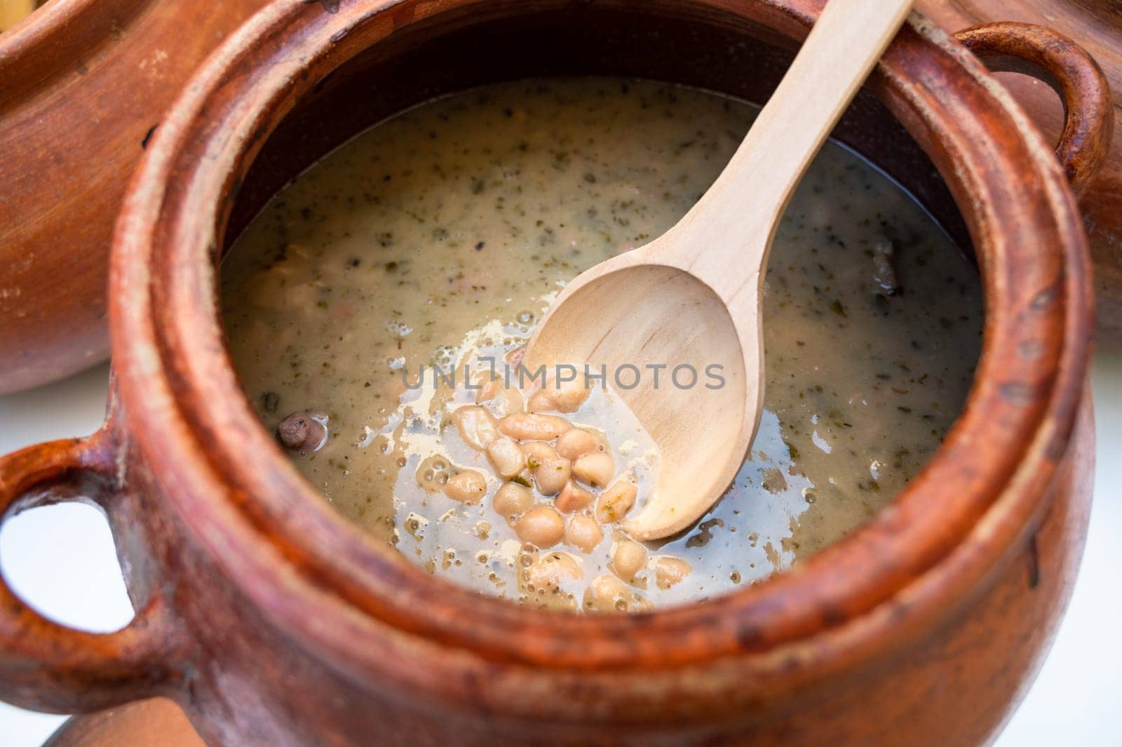 Clay pot with traditional Peruvian food called seco con frejoles. by Peruphotoart