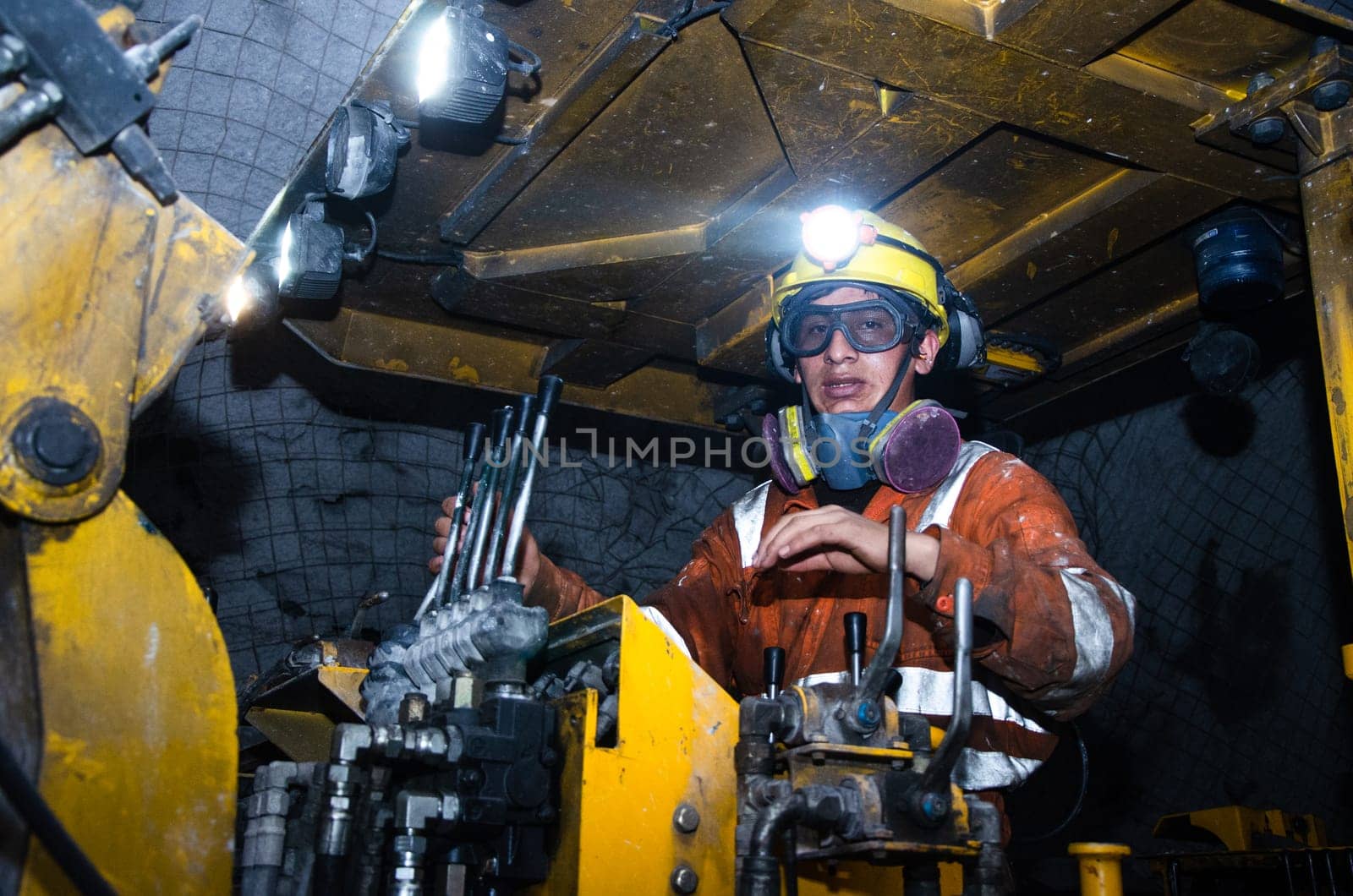 Miner operating a Jumbo Drill in an underground mine. by Peruphotoart