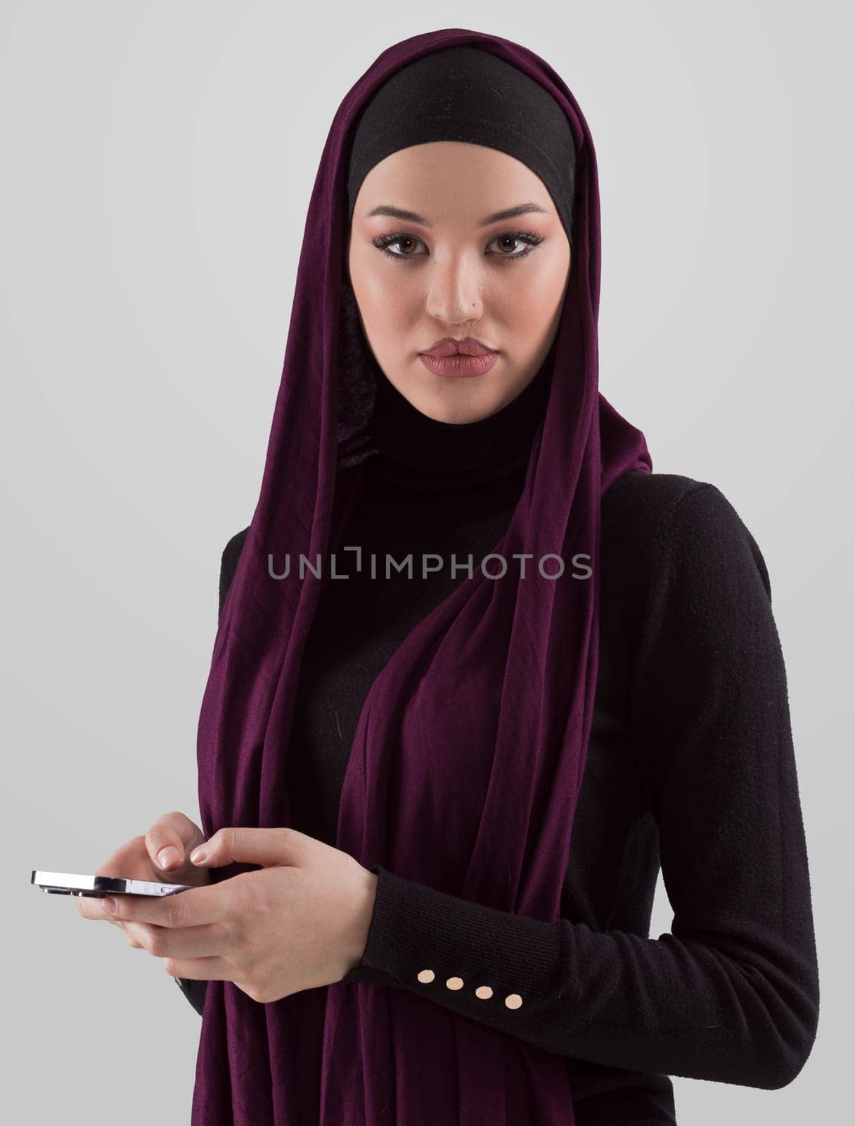 Woman in black stylish fashionable clothes Muslim headscarf. Lady using smart phone, close up portrait of smiling middle eastern girl. by dotshock