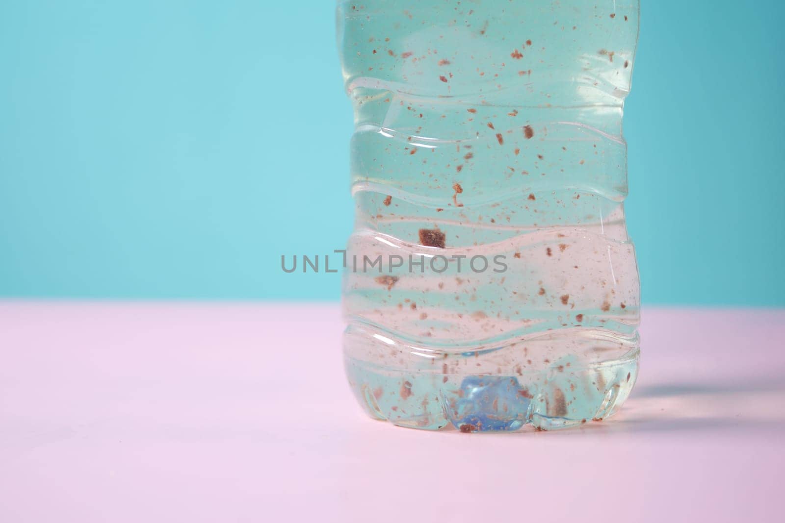 dirty bottle of water on table by towfiq007