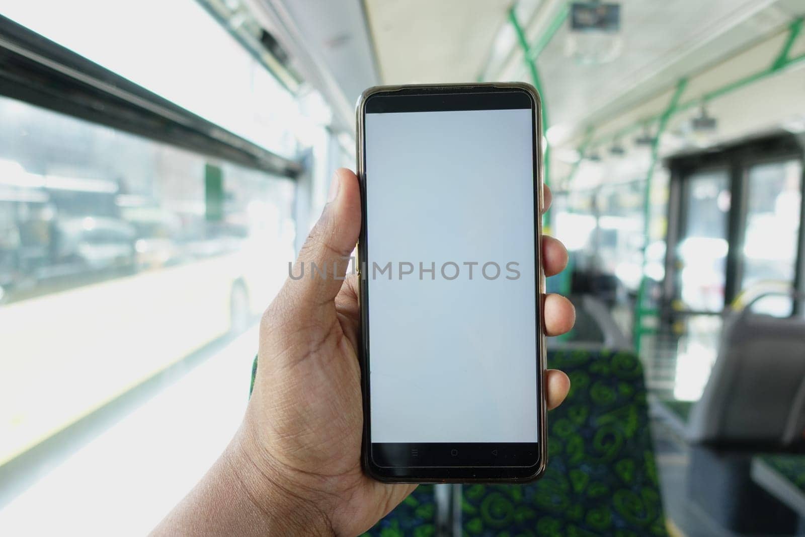 passenger sitting in a bus using his phone