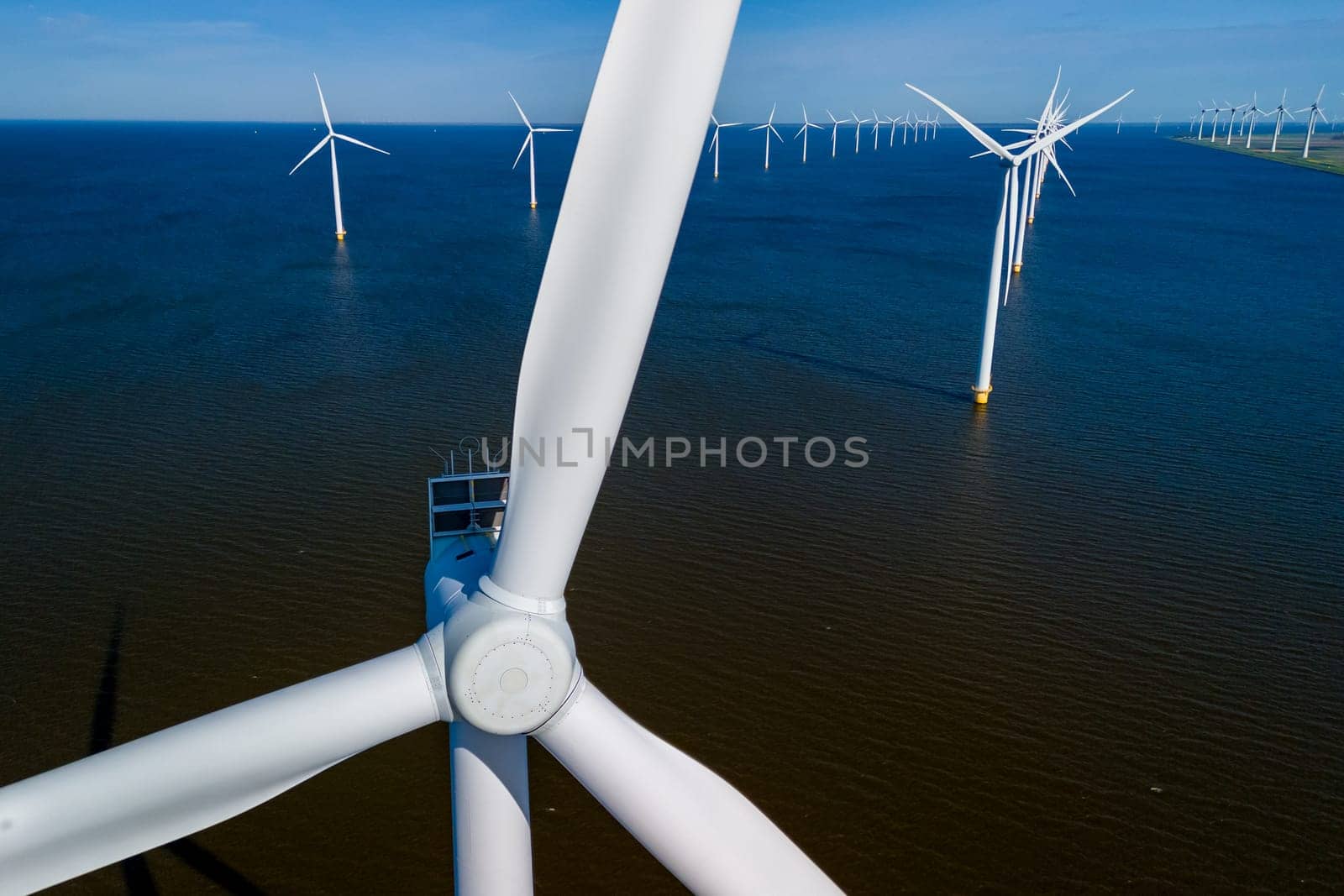 A mesmerizing sight of a group of wind turbines gracefully spinning in the ocean by fokkebok