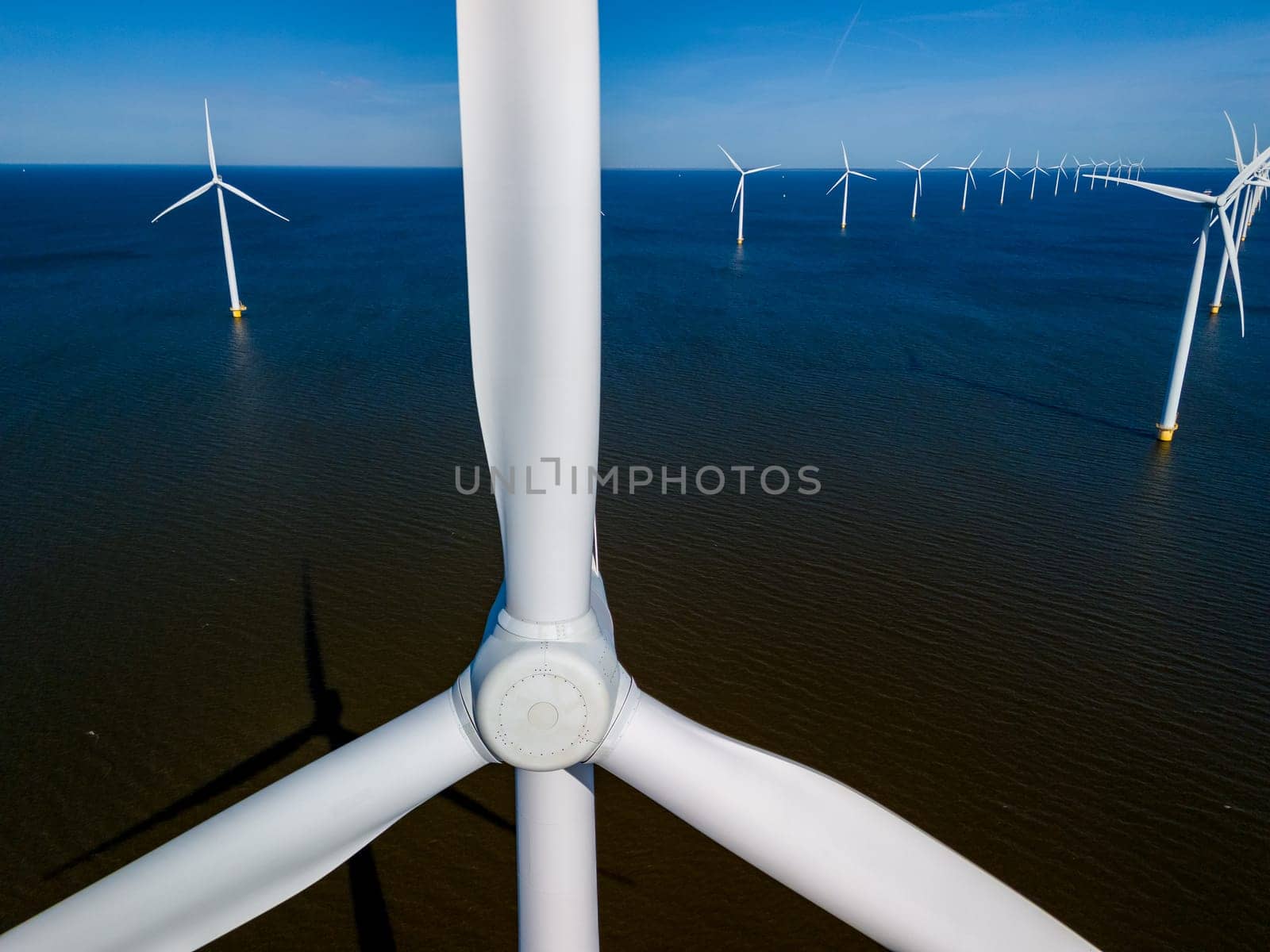 A mesmerizing aerial view of a wind farm featuring rows of windmill turbinesin Spring by fokkebok