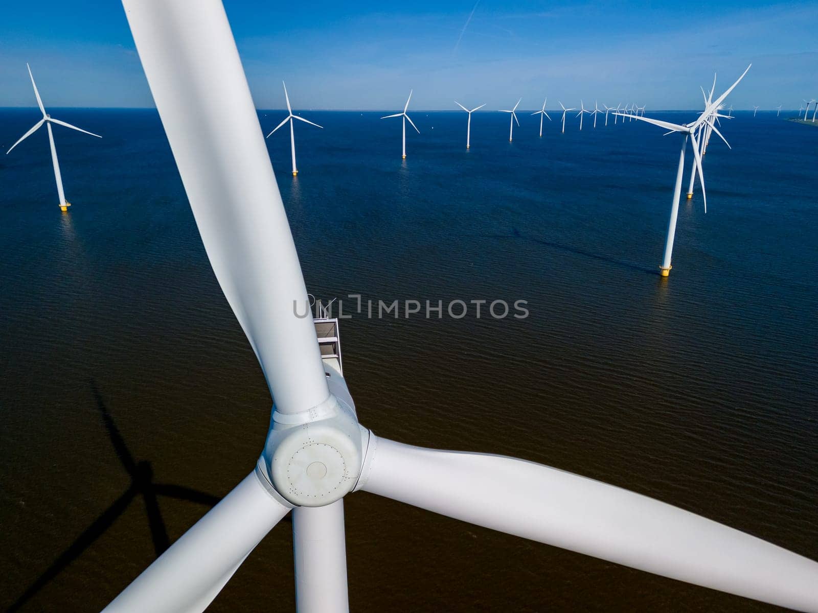 A group of majestic wind turbines stand tall in the ocean,wind to generate clean energy in Flevoland by fokkebok