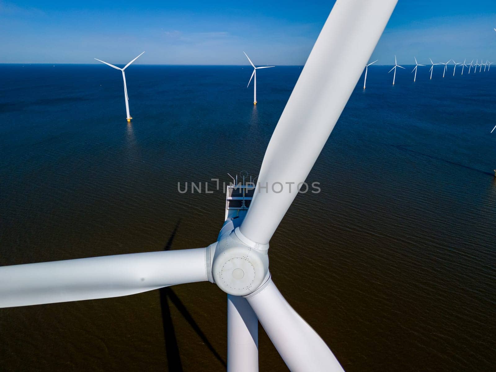 A view of wind turbines in the ocean, creating renewable energy in the vibrant Spring season by fokkebok