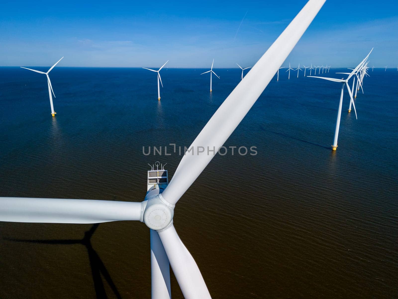 Majestic windmill turbines rise from the waters of the Netherlands Flevoland by fokkebok