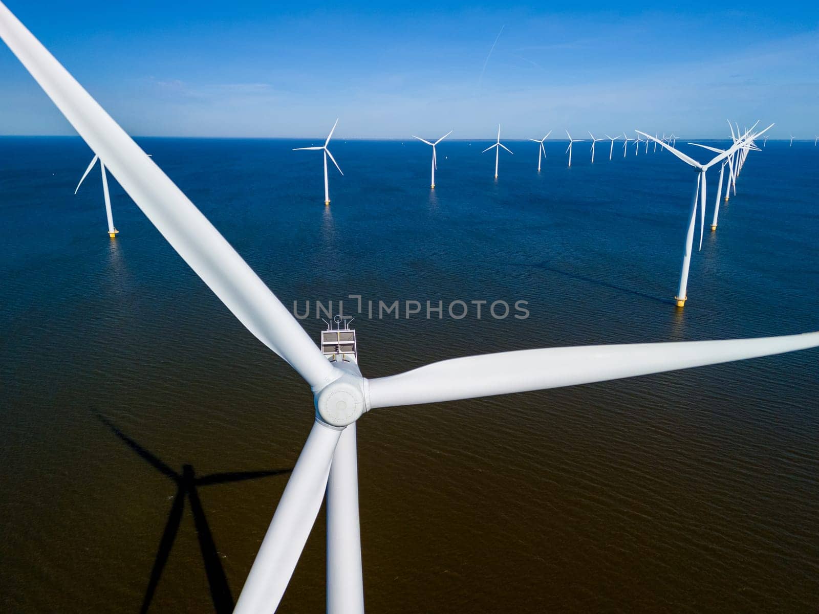 A wind farm in the middle of the ocean in the Netherlands Flevoland, with windmill turbines by fokkebok