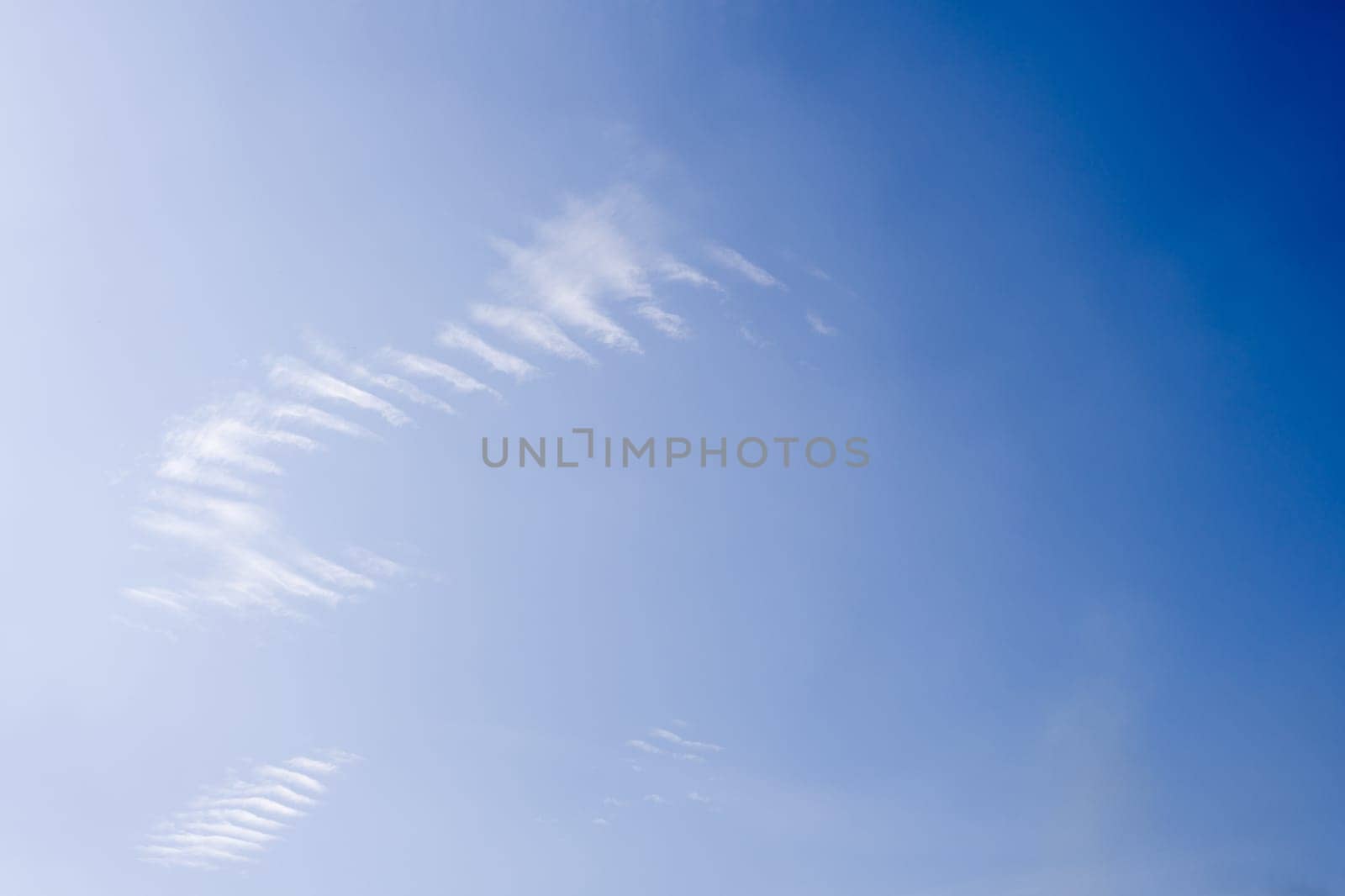 White spindrift clouds on blue sky, background by zartarn