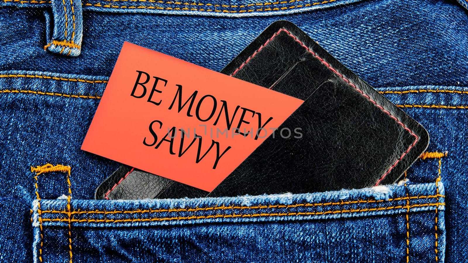 Savings concept,Text Be money savvy on business cards from a purse from a jeans pocket by Ihar