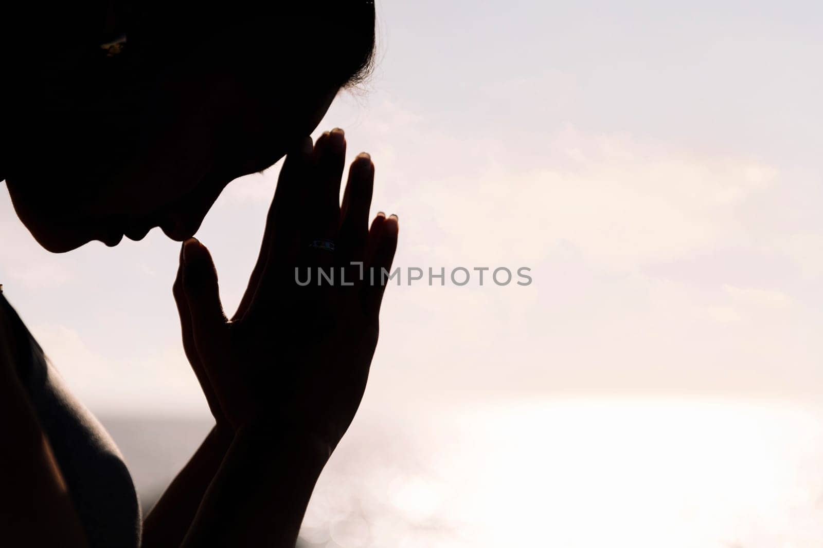 backlight portrait of young asian woman practicing yoga in pray position, concept of mental relaxation and healthy lifestyle, copy space for text