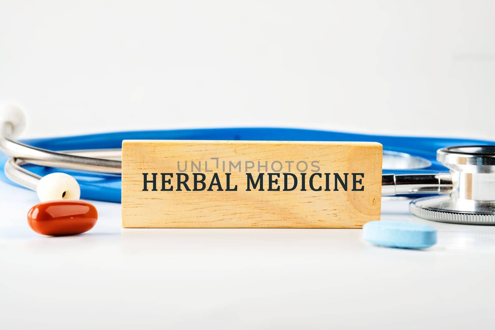Medical concept. HERBAL MEDICINE text on a wooden block on a gray background