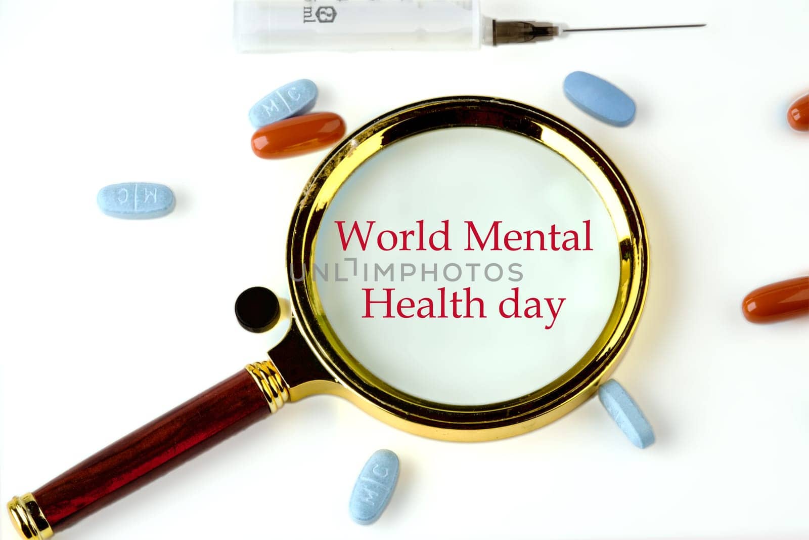 Depression and support concept. World mental health day through a magnifying glass on a white background with pills and vitamins lying next to it