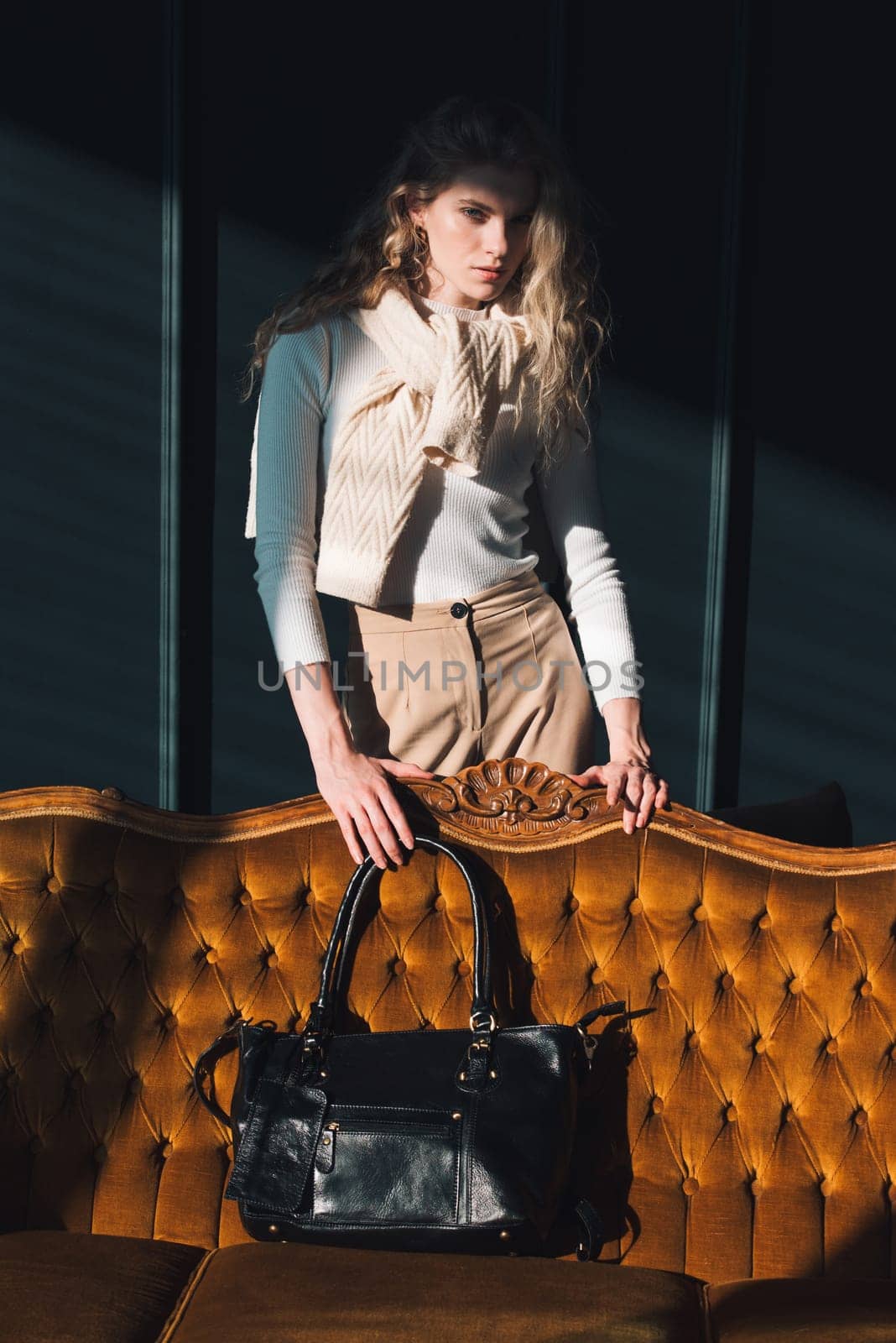 beautiful curly blond hair woman posing with a small black shopper bag near vintage volor sofa by Ashtray25