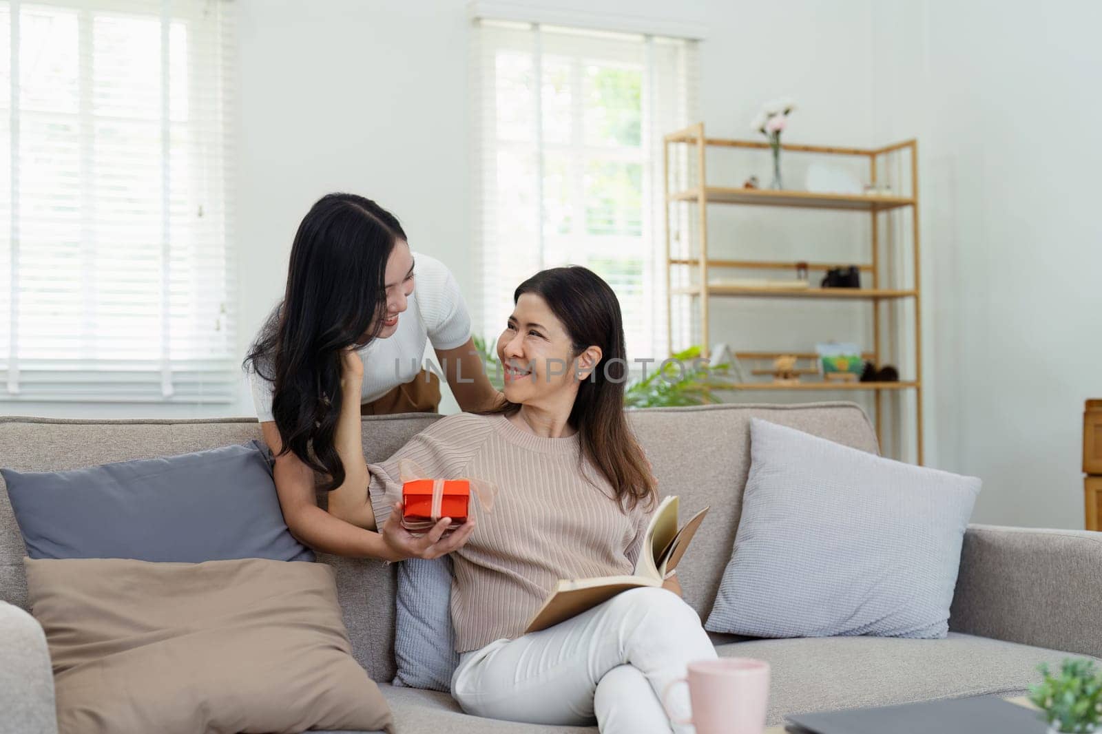 Congratulations. Loving asian mature daughter surprised mother with present in Mother's Day, giving her handmade card and gift box by itchaznong