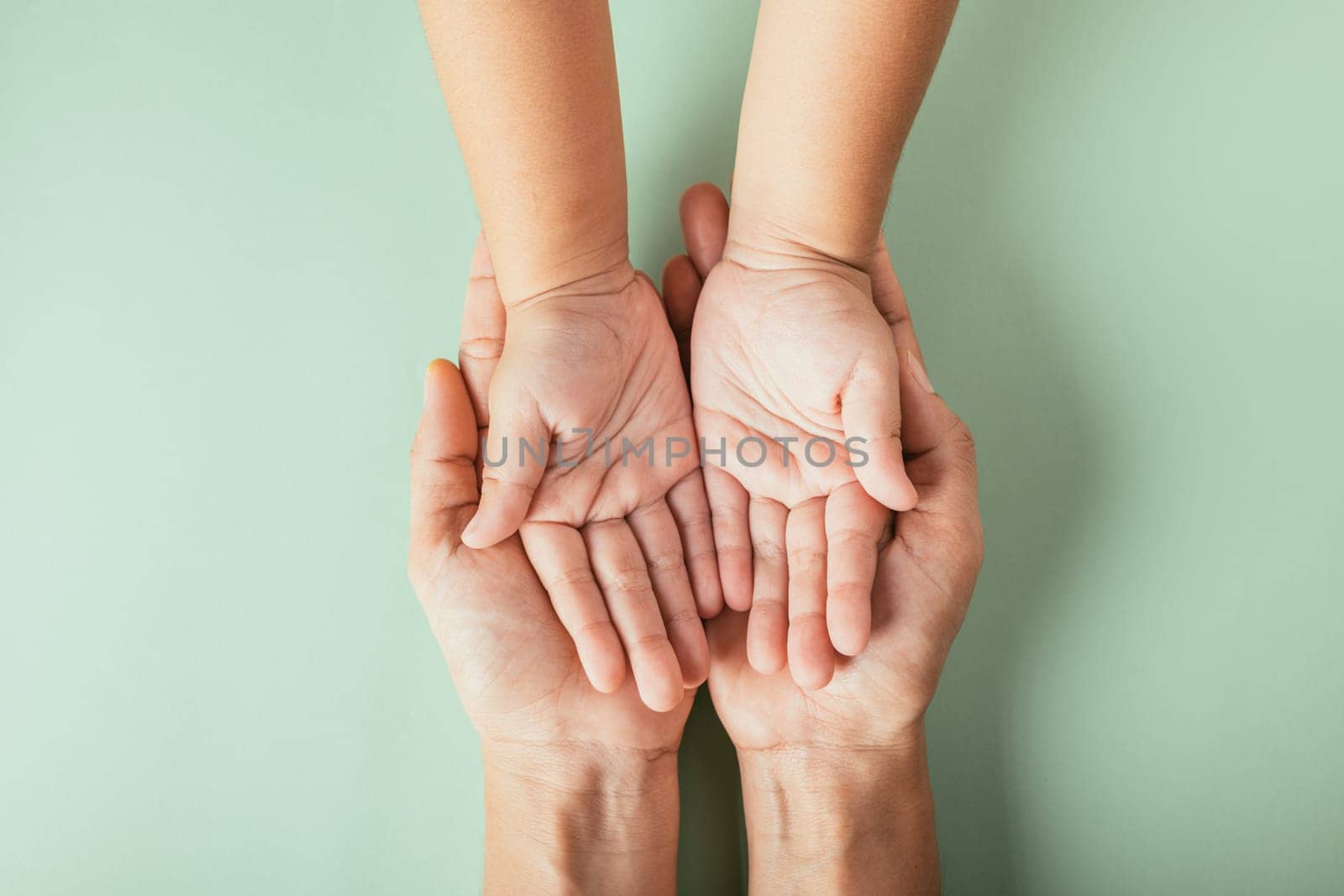 Top view of parents and kid holding empty hands isolated on a color background. Celebrating Family Day symbolizing togetherness and generational support.