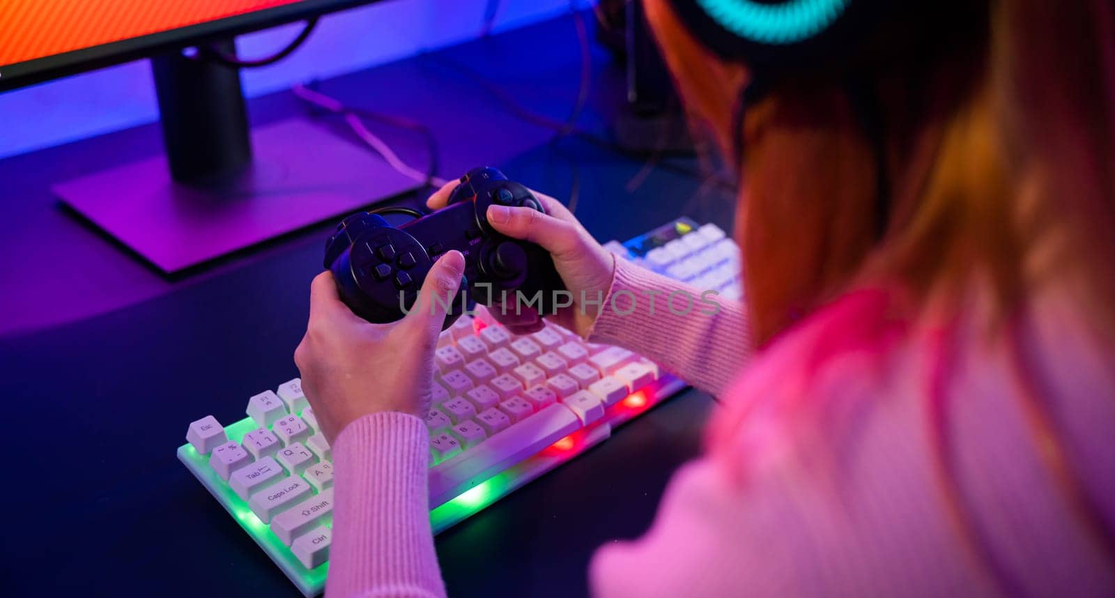Close up Woman wear gaming headphones playing live stream esports games console at home, Gamer using joystick controller for virtual tournament plays online video game with computer neon lights