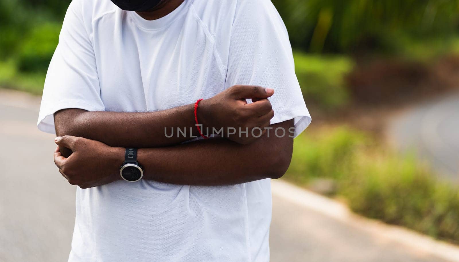 Close up Asian young sport runner black man wear watch he having elbow pain and use hands joint hold elbow while exercising at the outdoor street health park, healthy exercise Injury from workout