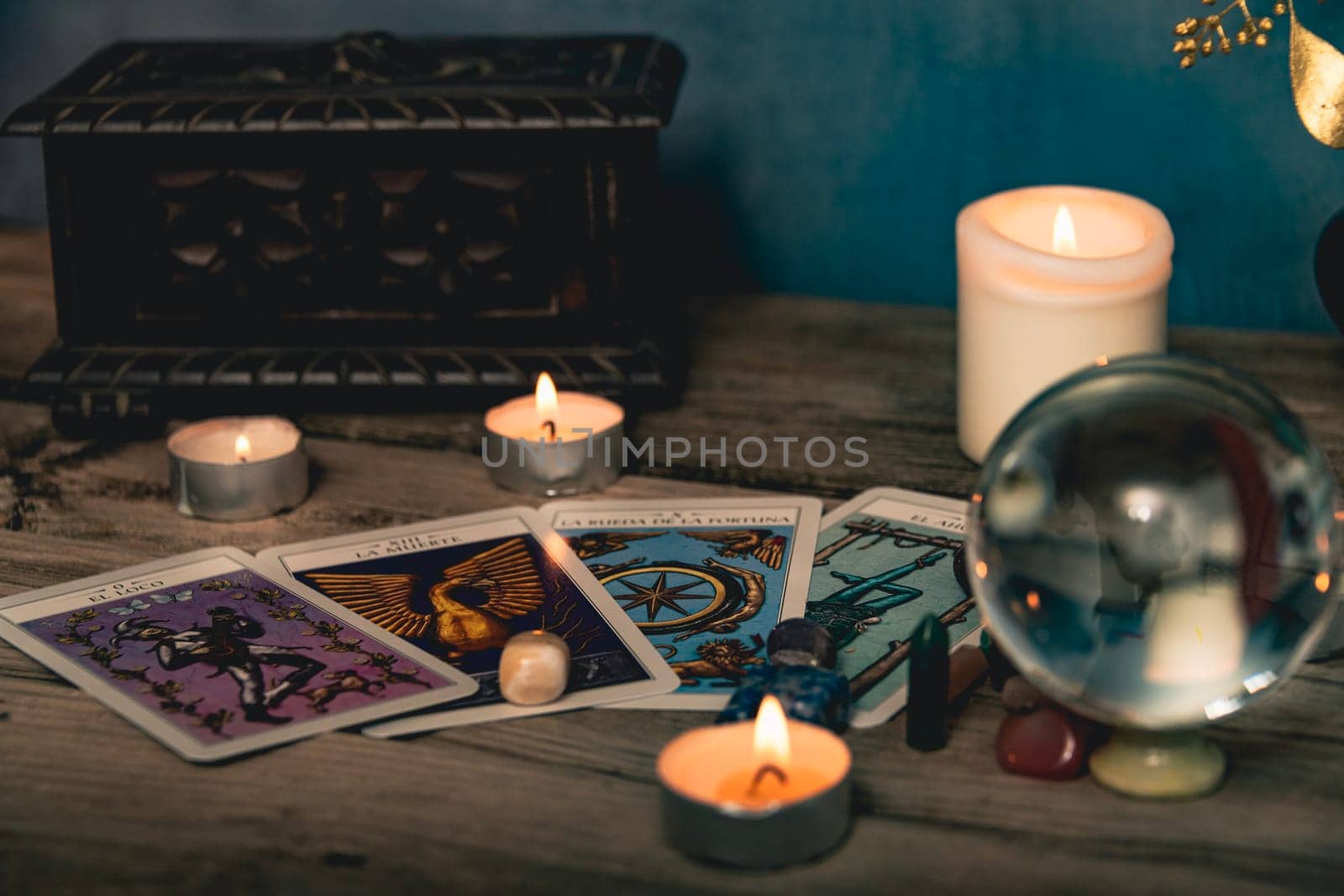 Tarot cards including The Fool and The Lovers alongside crystals and candles on a textured wooden table