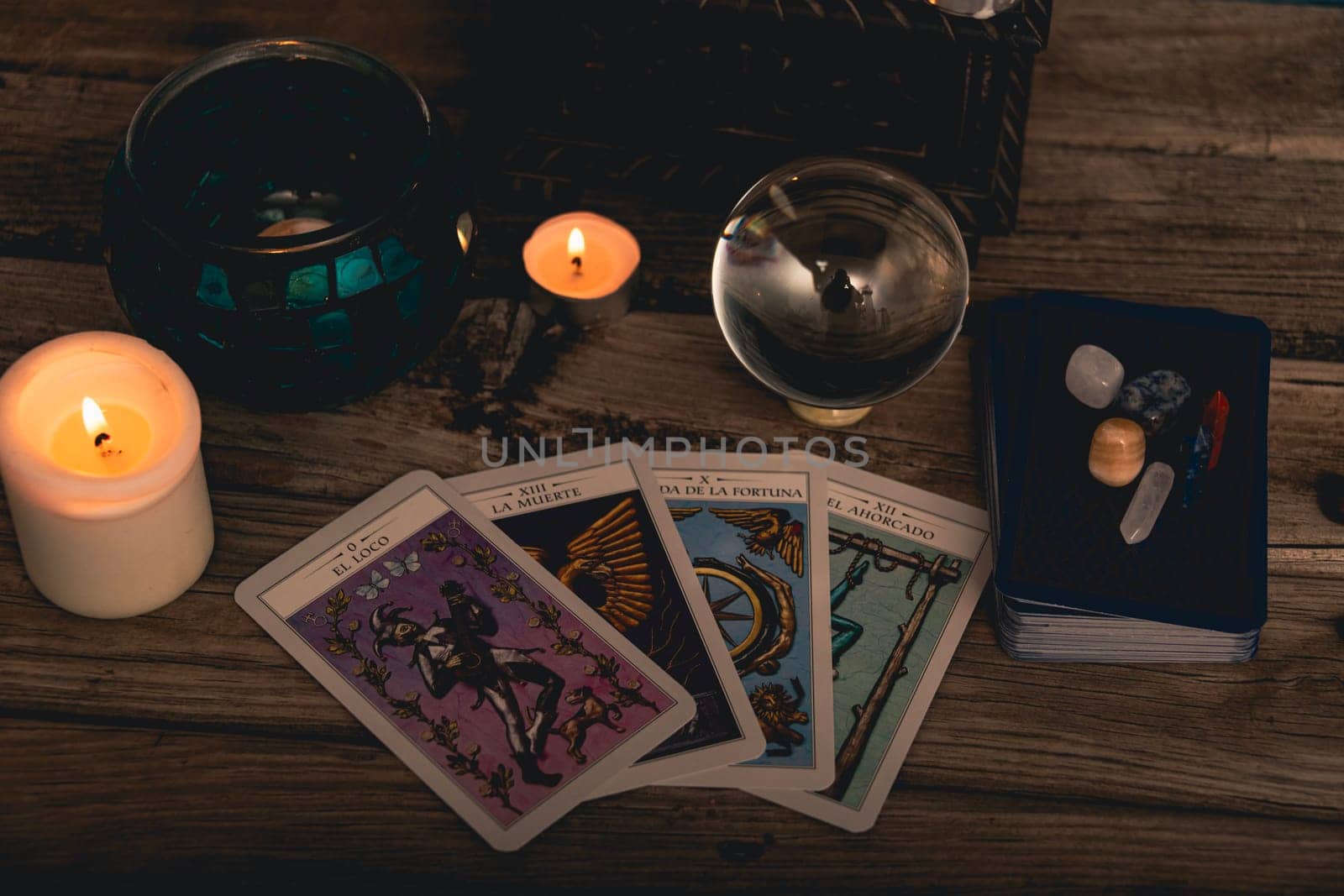 Tarot cards including The Fool and The Lovers alongside crystals and candles on a textured wooden table