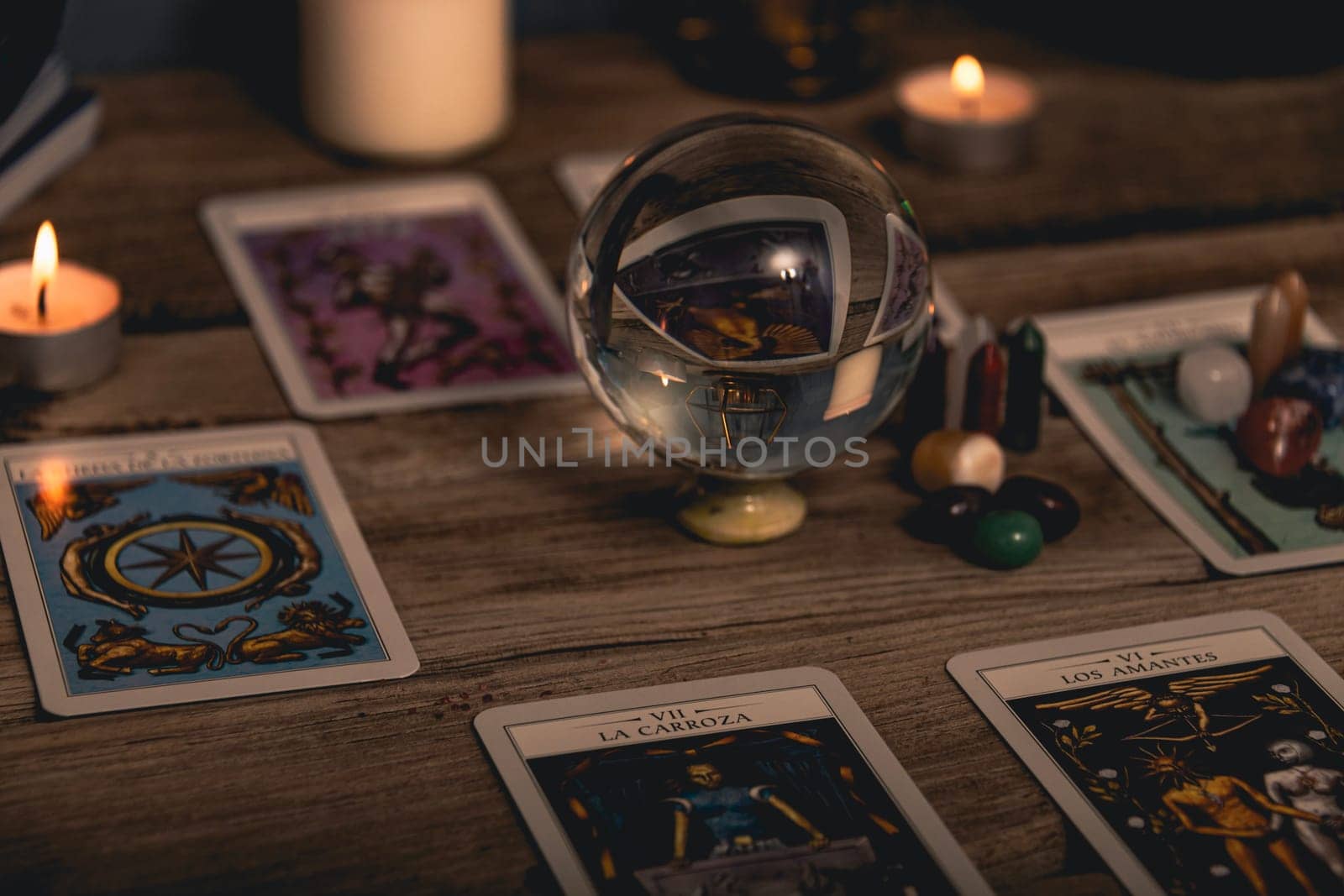 Tarot cards including The Fool and The Lovers alongside crystals and candles on a textured wooden table