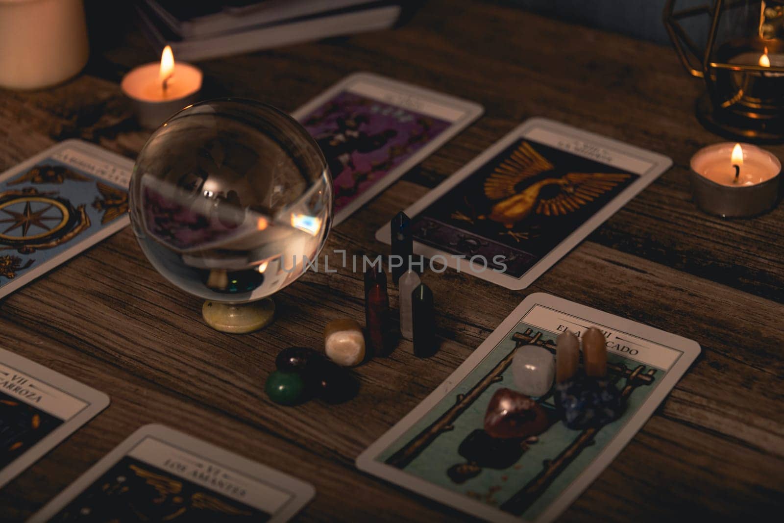 Tarot cards including The Fool and The Lovers alongside crystals and candles on a textured wooden table