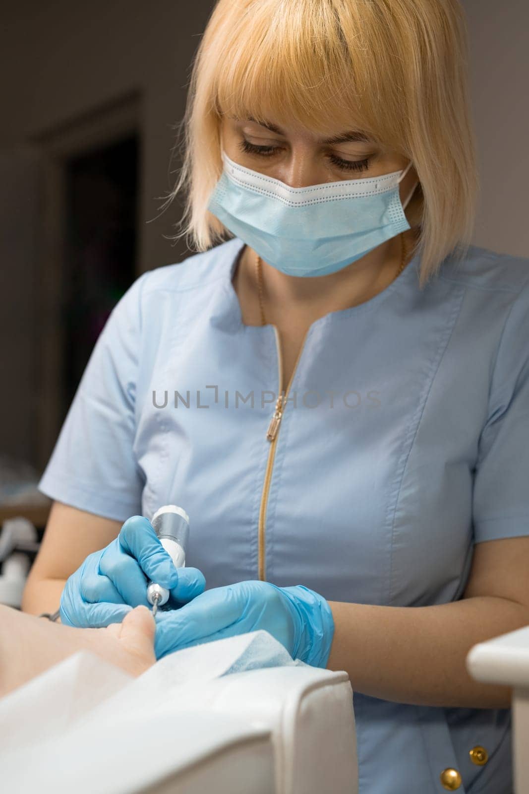 Podologist in face mask during the process of removing an ingrown toenail.