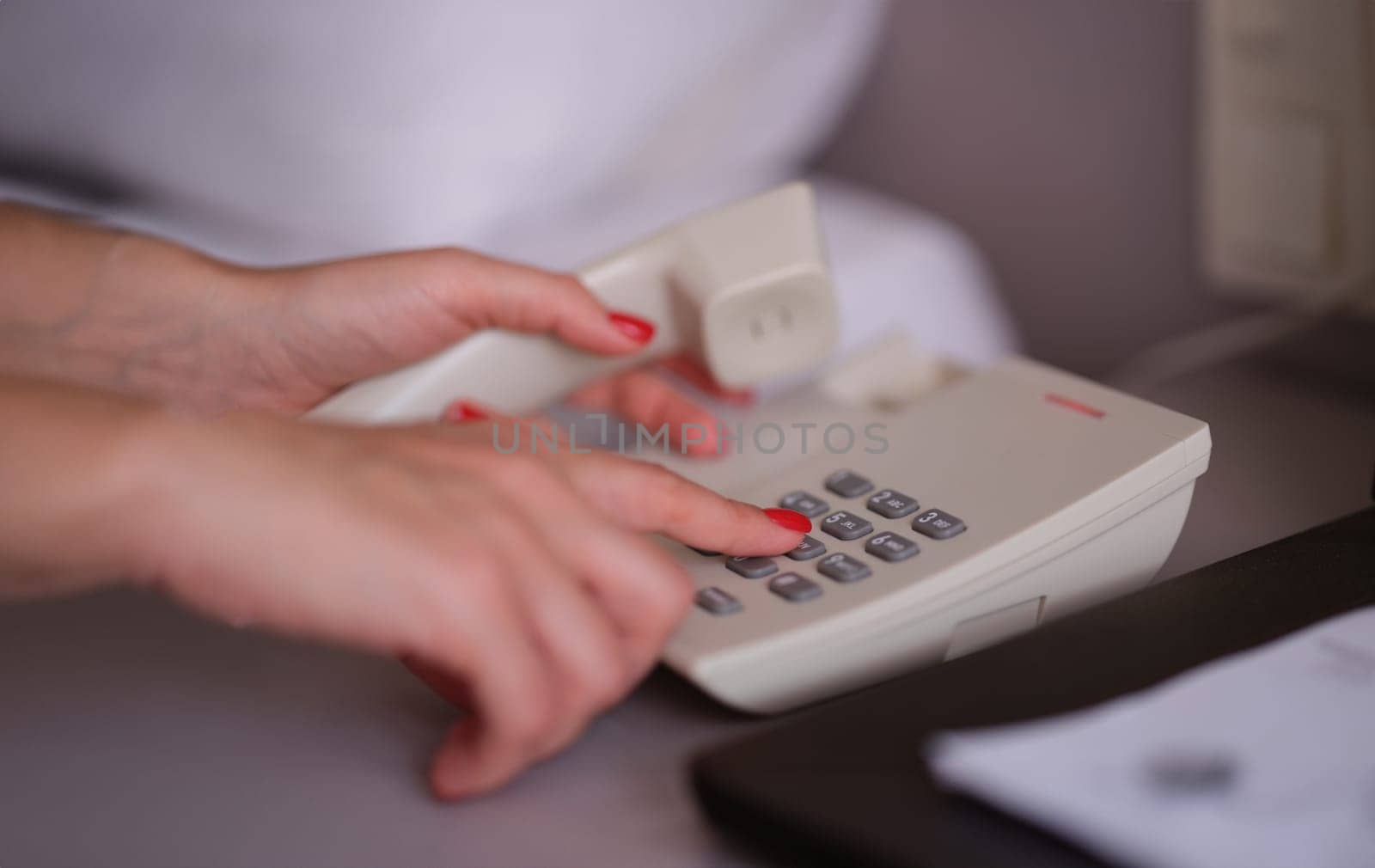 Business woman dialing phone number in hotel room. Hotel services and staff call concept