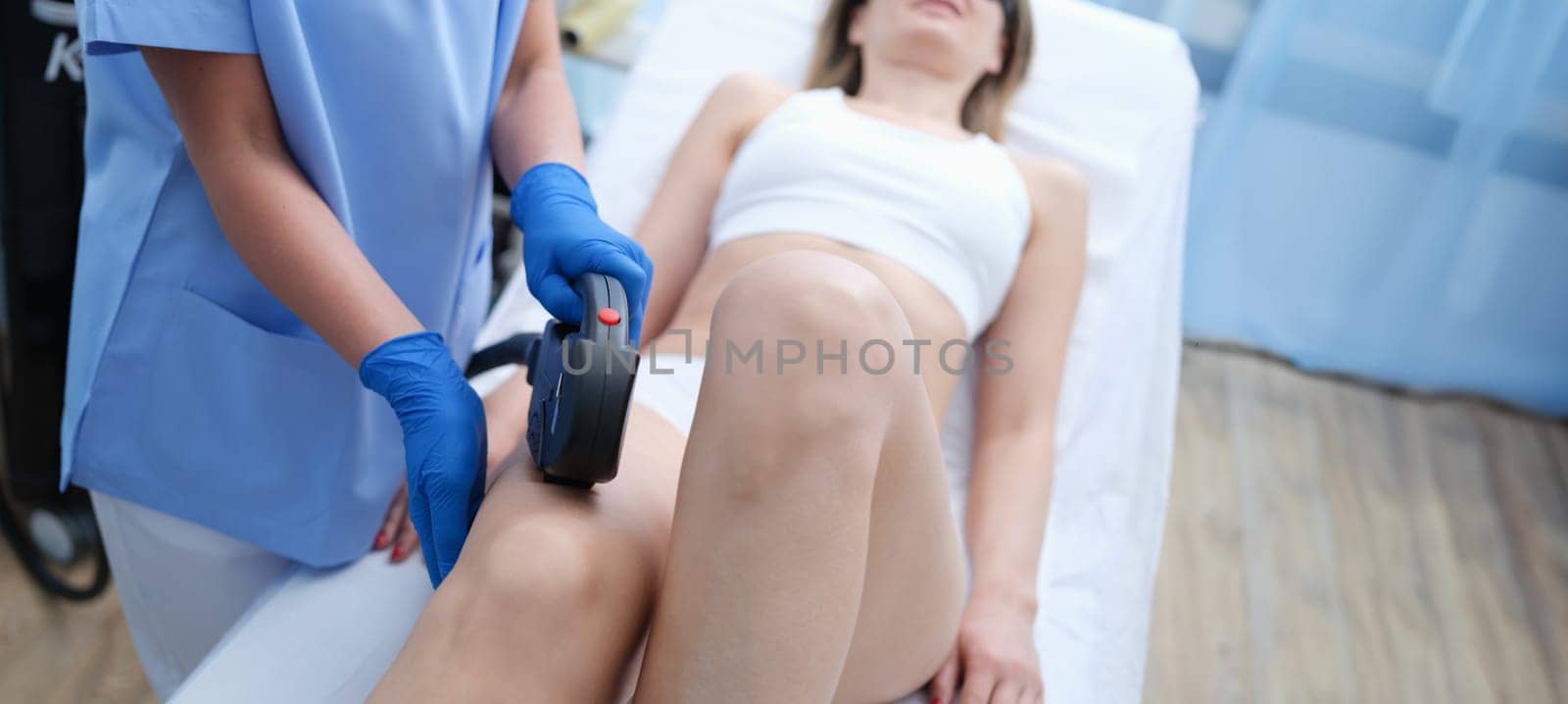 Laser hair removal on beautiful female legs in beauty clinic by kuprevich