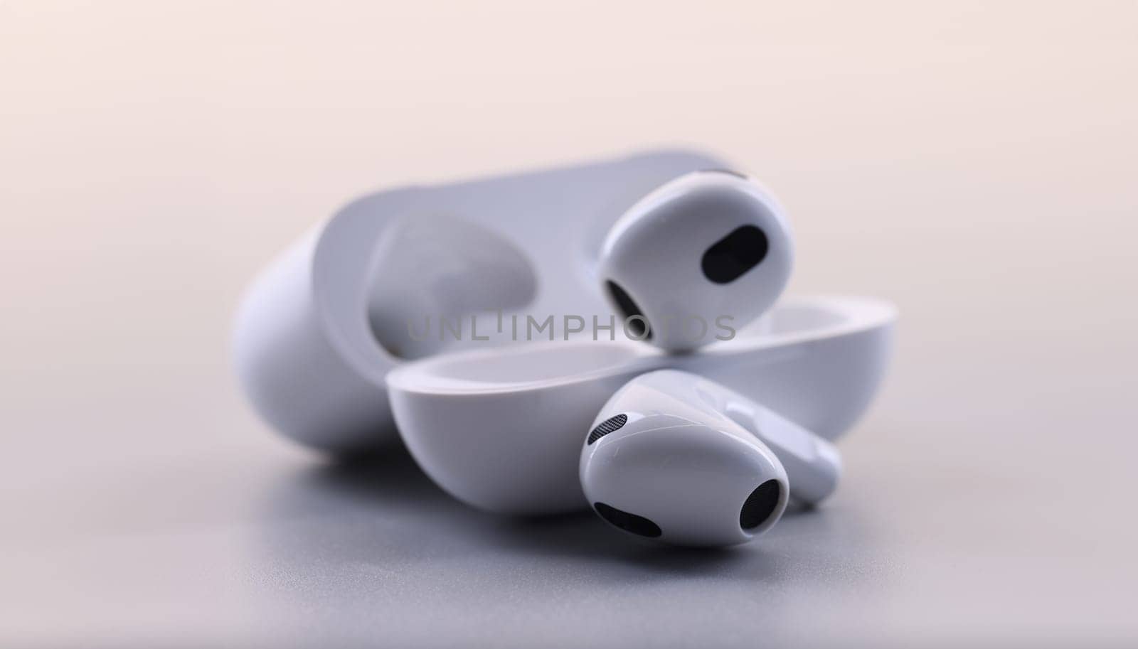 White electronic bluetooth headphones and technical cases on white background. Fashion stylish headphones concept