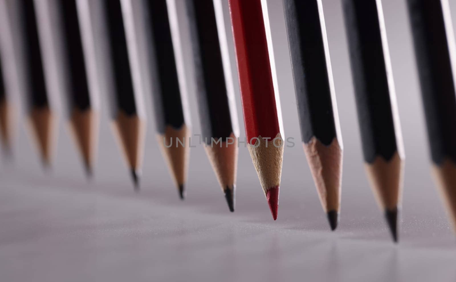Black pencils in the center with red. Leadership uniqueness and business success concept