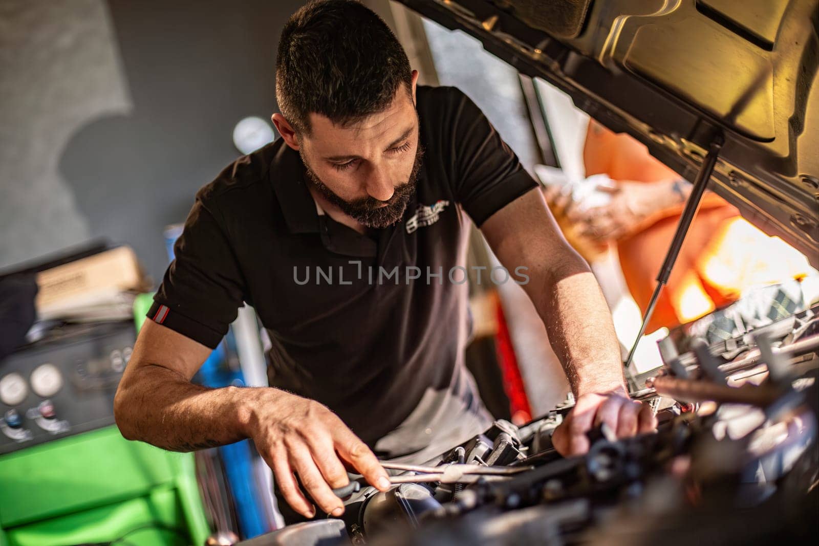 Milan, Italy 9 April 2024: Mechanic's hands delve into car engine under the hood, symbolizing repair and maintenance.