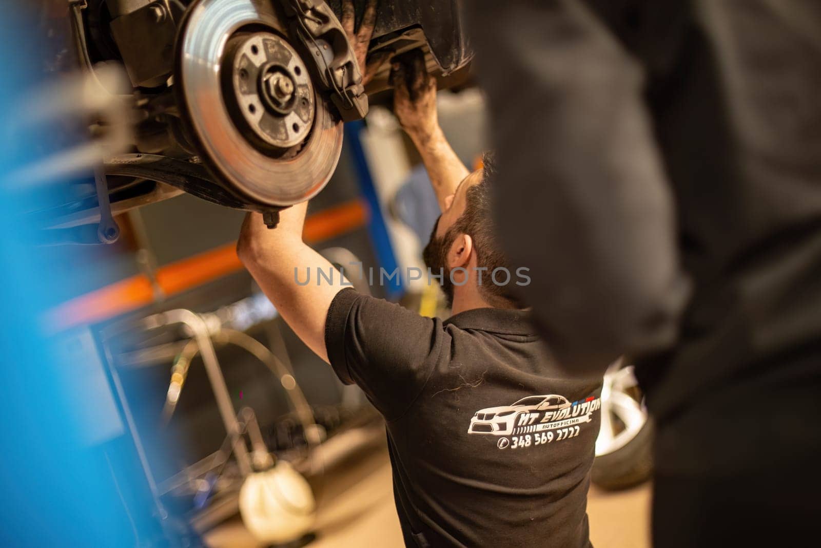 Milan, Italy 9 April 2024: Mechanic's hands delve into car engine under the hood, symbolizing repair and maintenance.