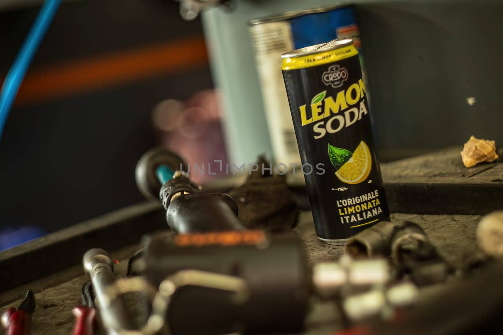 Milan, Italy 9 April 2024: A lemon soda can placed among various tools on a workshop bench.