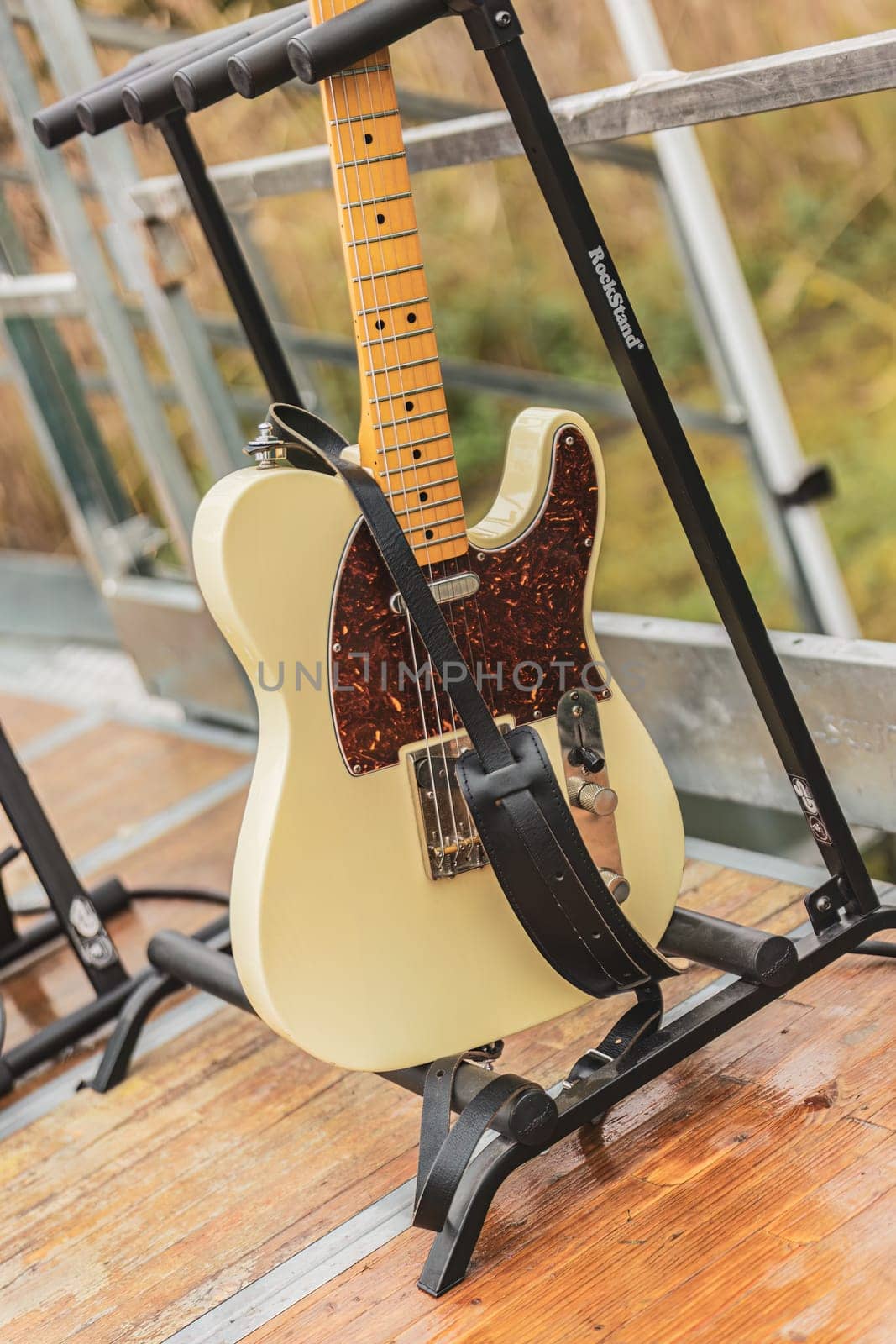 Milan, Italy 1 April 2024: A white guitar stands elegantly on top of a weathered wooden floor, emanating a sense of musical prowess and artistic elegance.