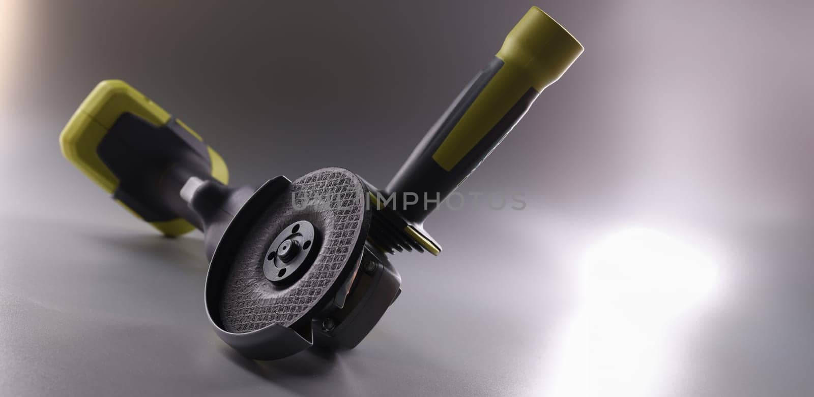 Professional angle grinder with disc on gray background. Construction tool concept