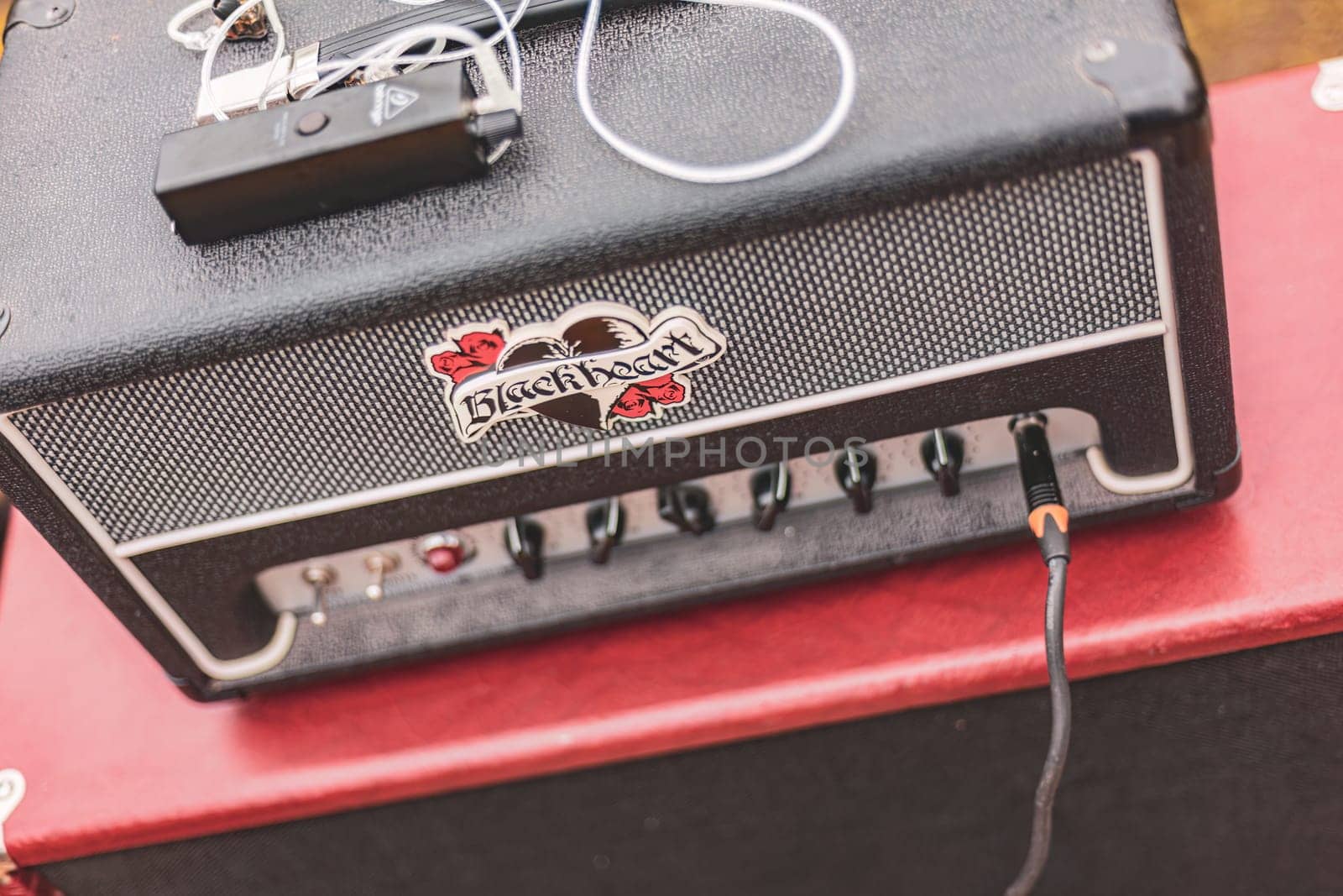 Milan, Italy 1 April 2024: A sleek black amplifier perched atop a vibrant red table, waiting to deliver powerful soundwaves to its audience.