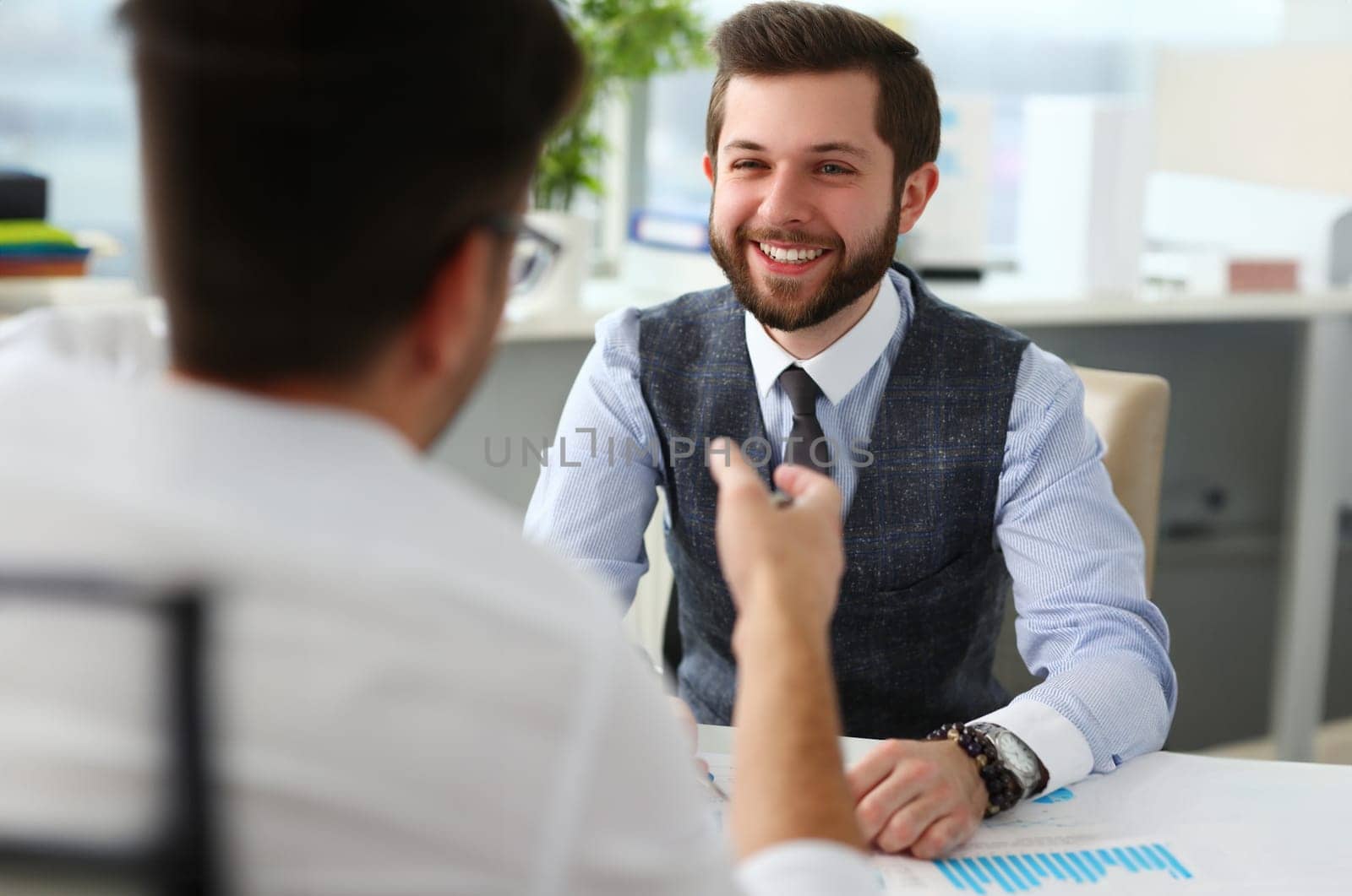 Smiling businessman communicates with business project partner. Business consultant discussing financial report