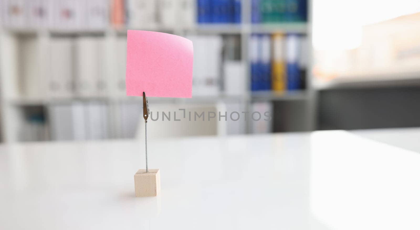 Office desk with pink sticker and paper clip by kuprevich