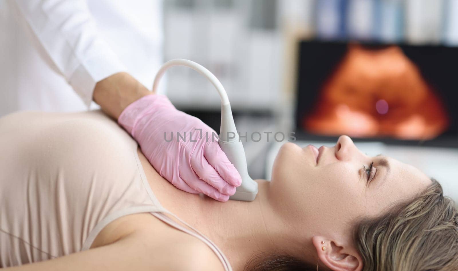 Ultrasound diagnosis of thyroid gland in young woman in clinic by kuprevich