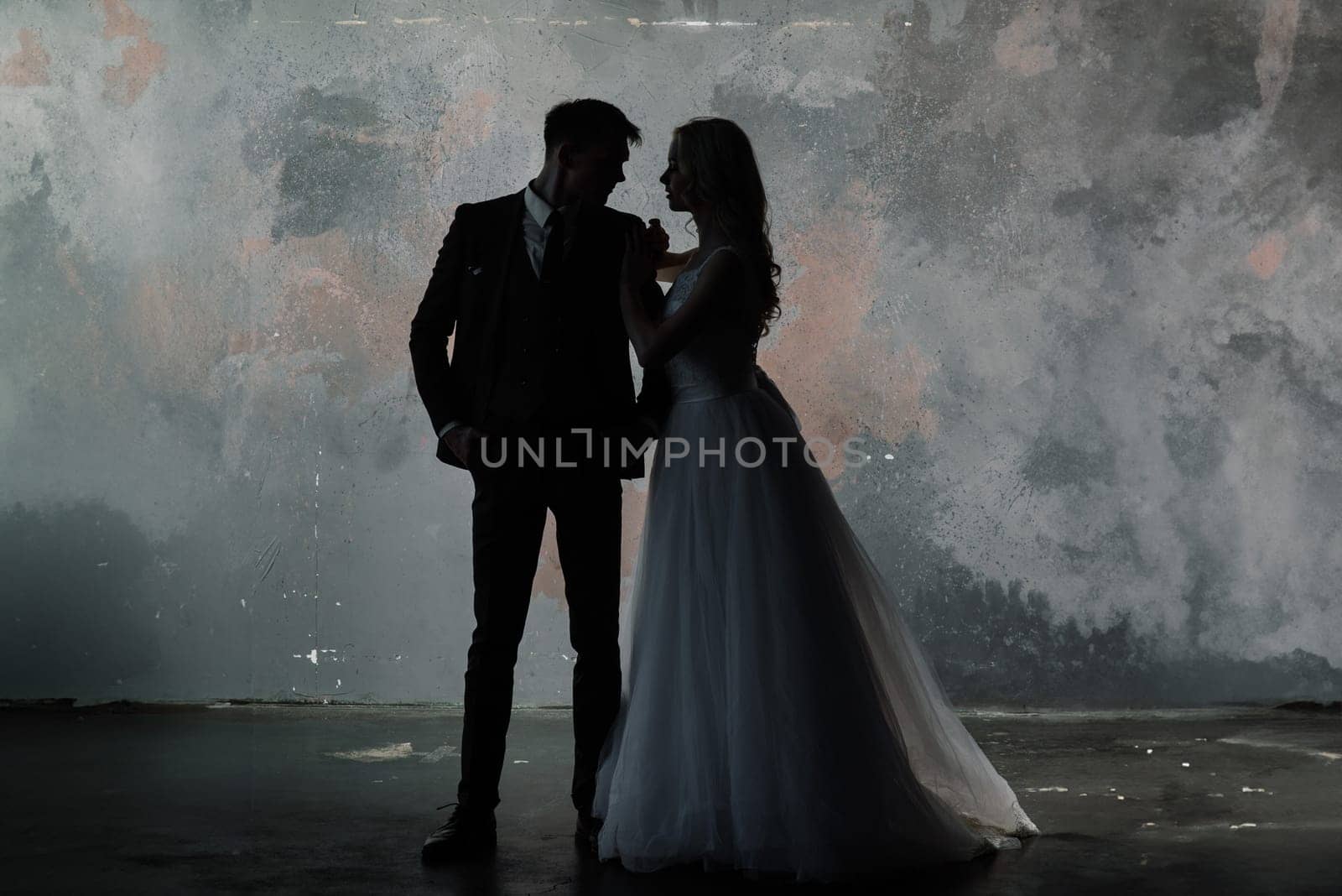 Art fashion studio photo of wedding couple silhouette groom and bride on colors background.