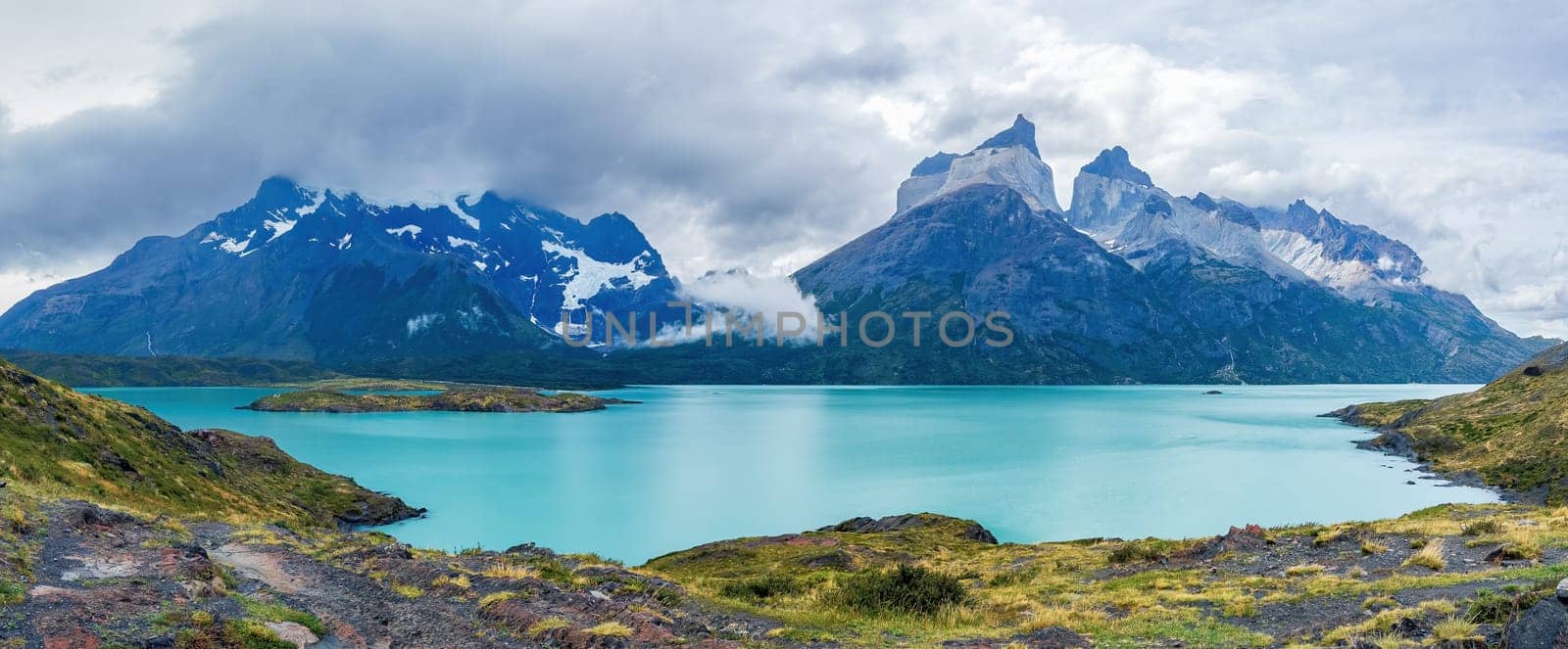 Tranquil panorama with snowy mountains and turquoise lake. Cuernos del Paine