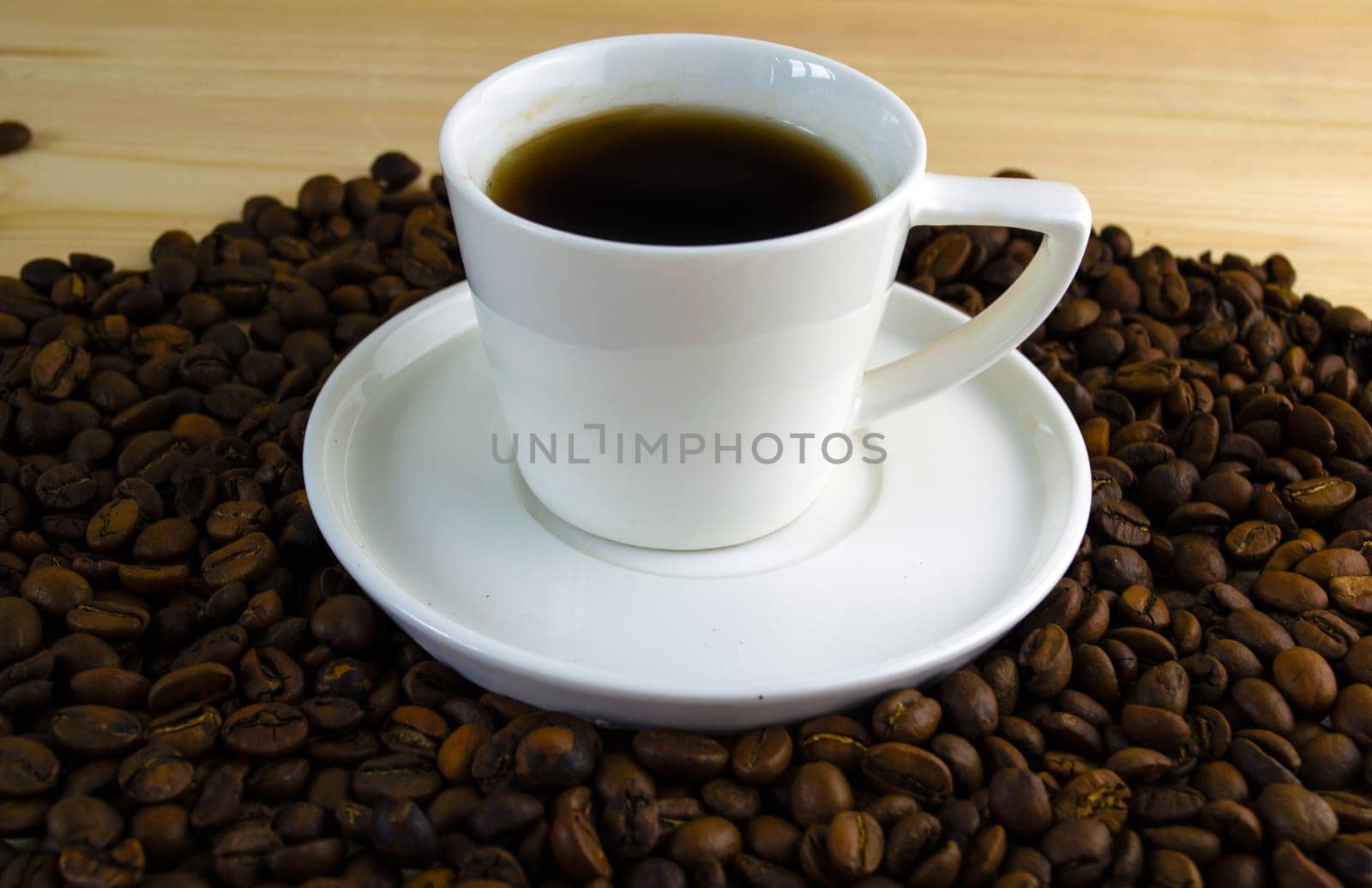 Coffee in a cup. A cup of coffee with a saucer on the background of coffee beans.