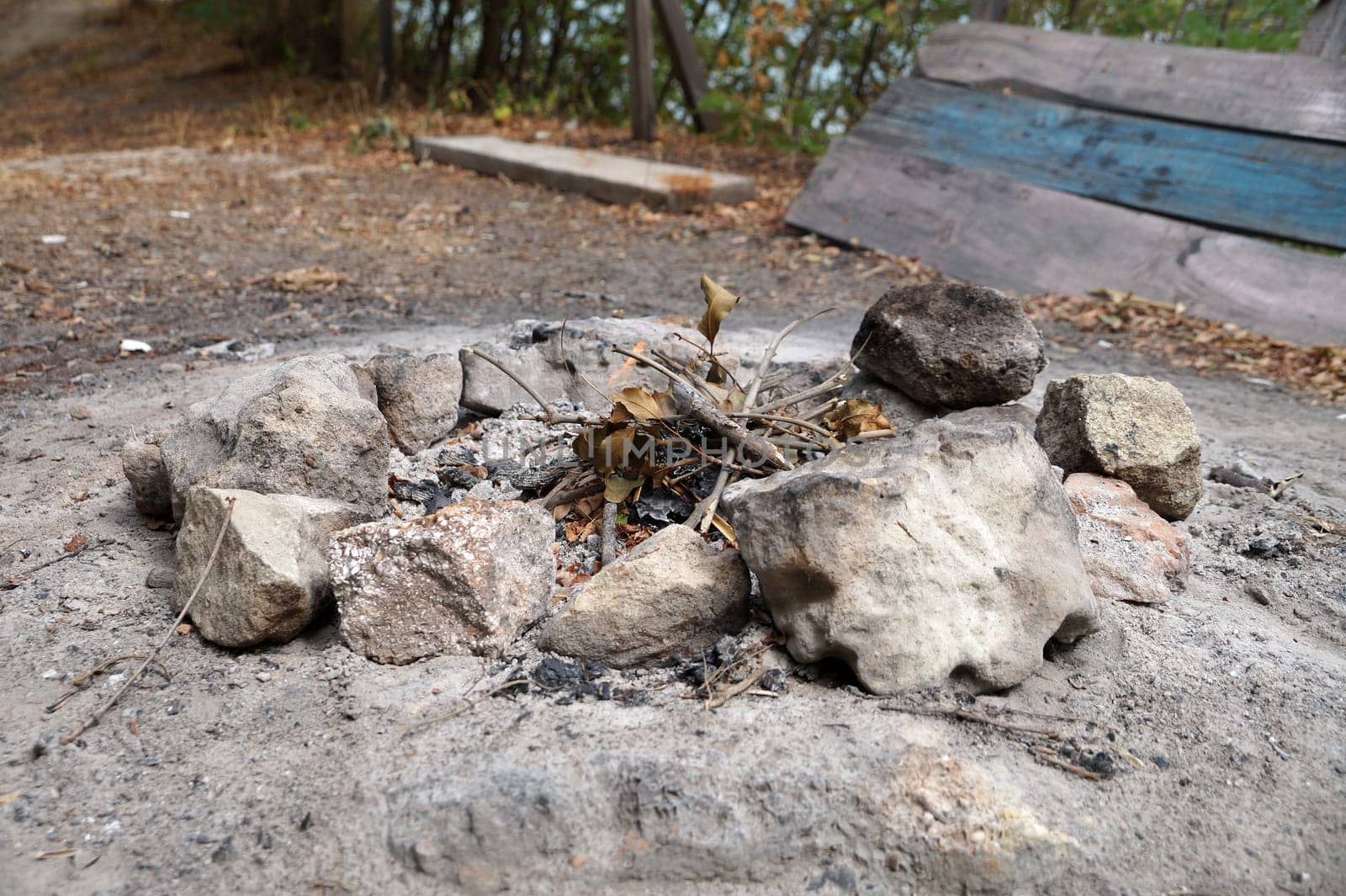 remnants of a campfire circled by stones outdoors by Annado