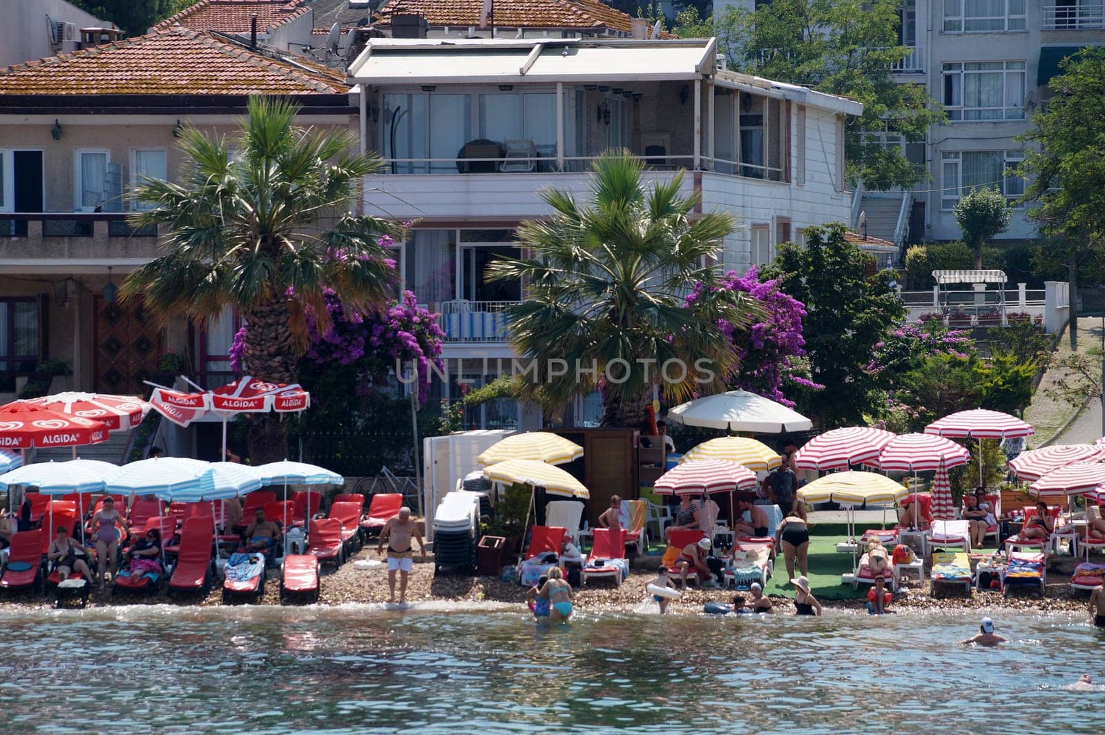 view of the beach with vacationing tourists on Buyukada island, Turkey
