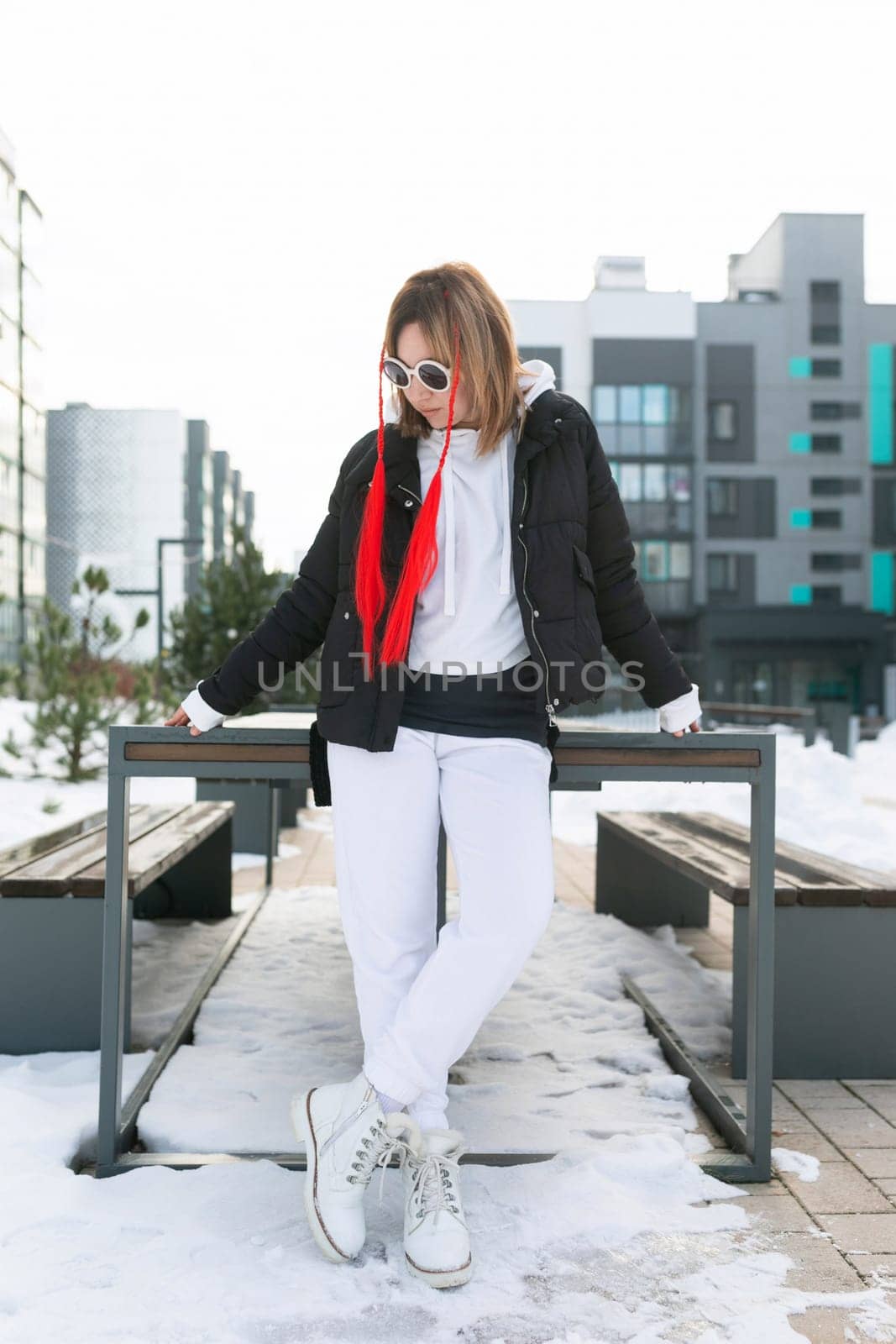 Happy woman walking down the street in snowy weather by TRMK