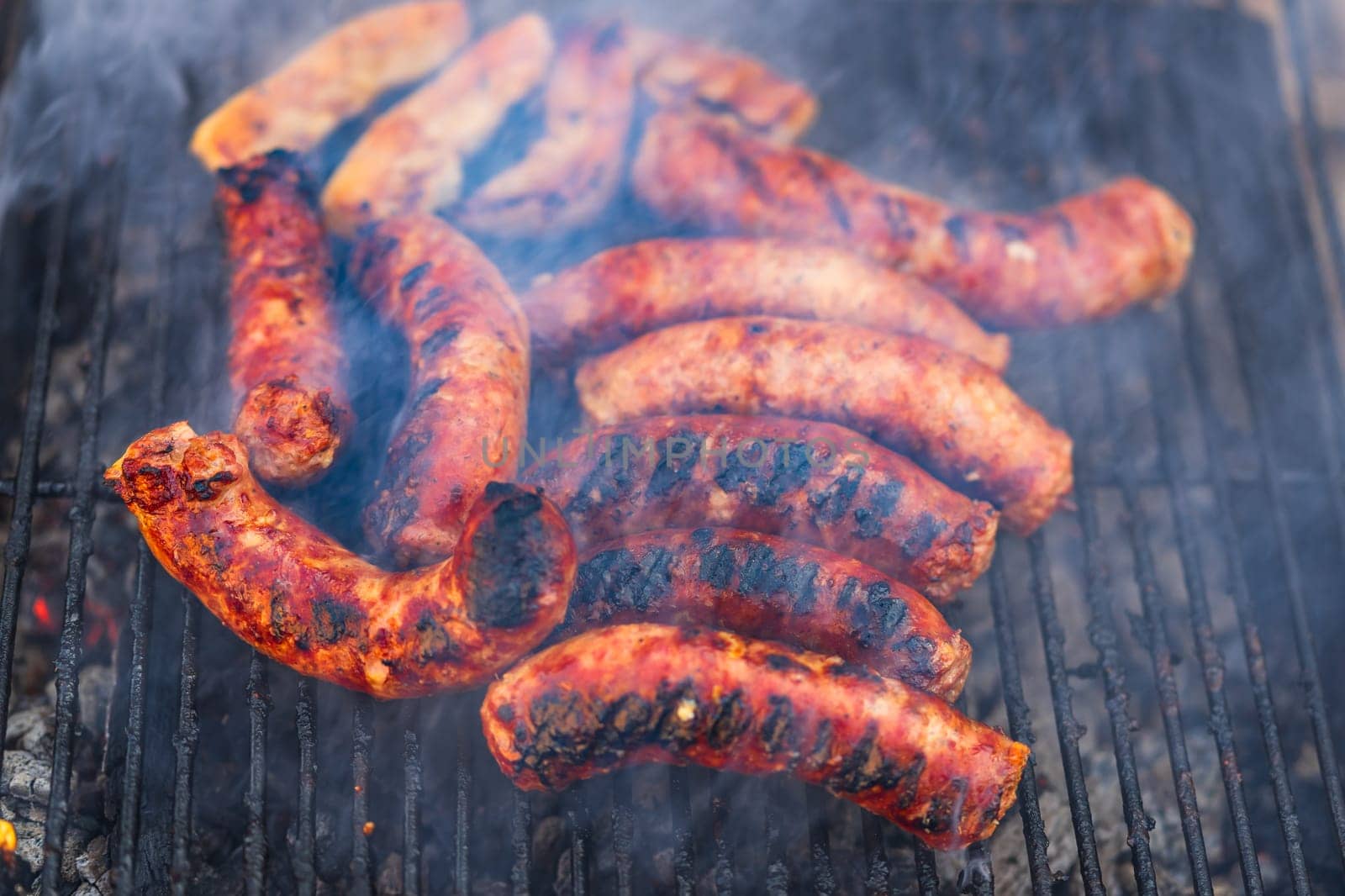 Grilling sausages on barbecue grill. Delicious sausages on charcoal grill
