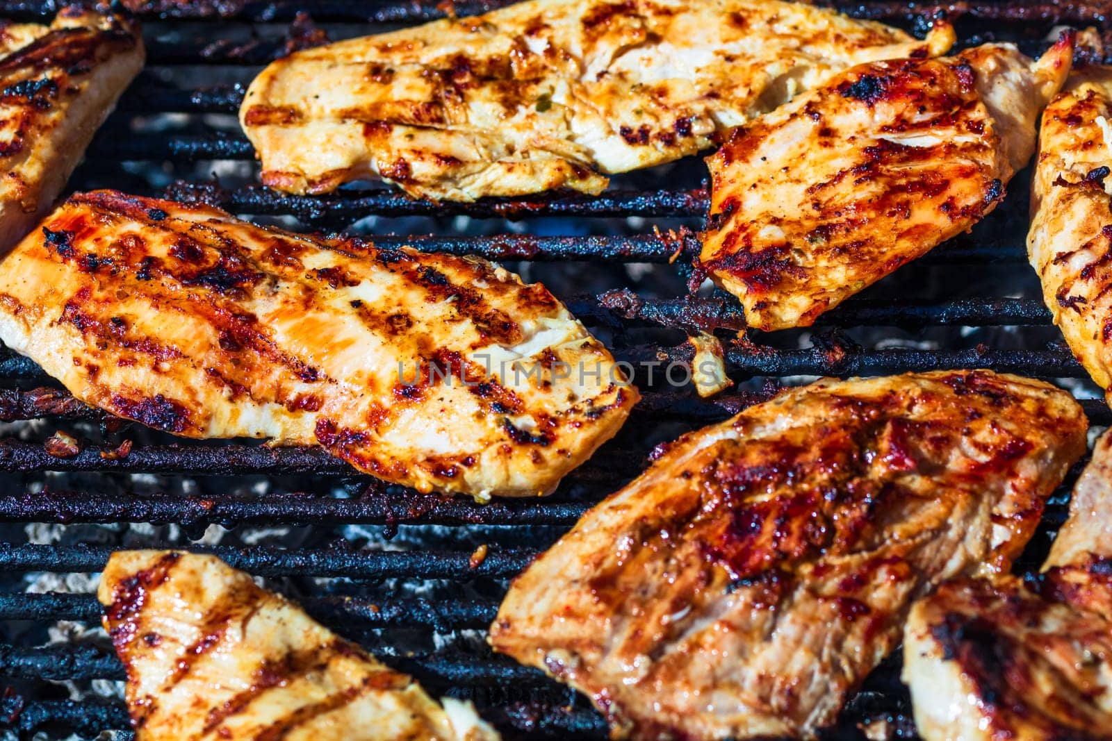 Chicken and pork steak grilled on a charcoal barbeque. Top view of camping tasty barbecue, food concept, food on grill and detail of food on the grill by vladispas