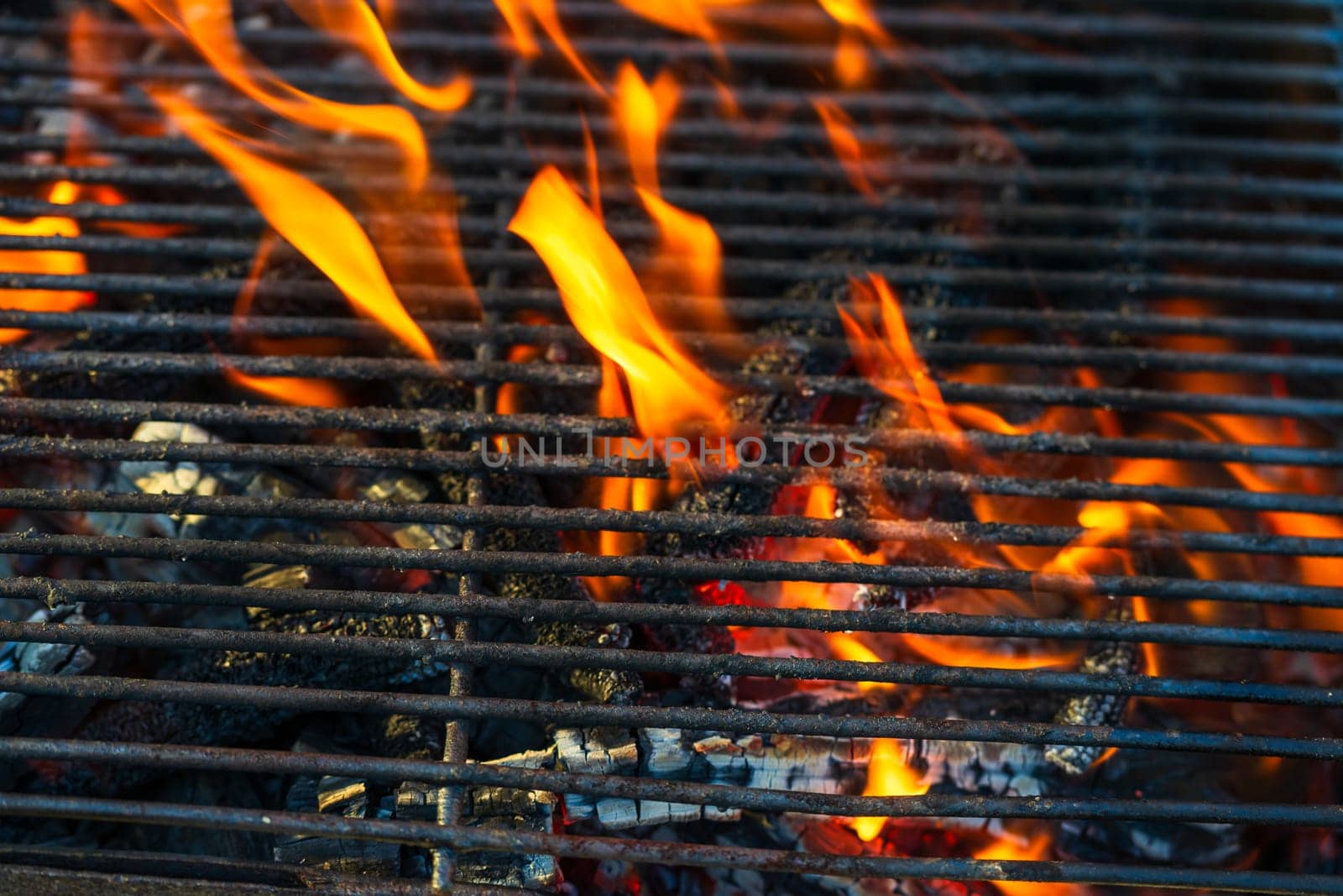 Empty hot charcoal barbecue grill with bright flame. Hot burning grill, outdoors cooking food by vladispas