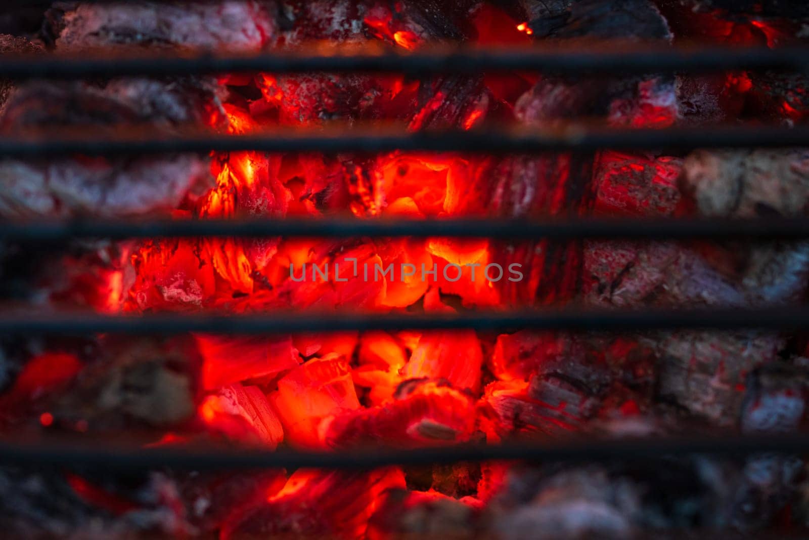 Barbecue grill pit with glowing and flaming hot charcoal briquettes by vladispas